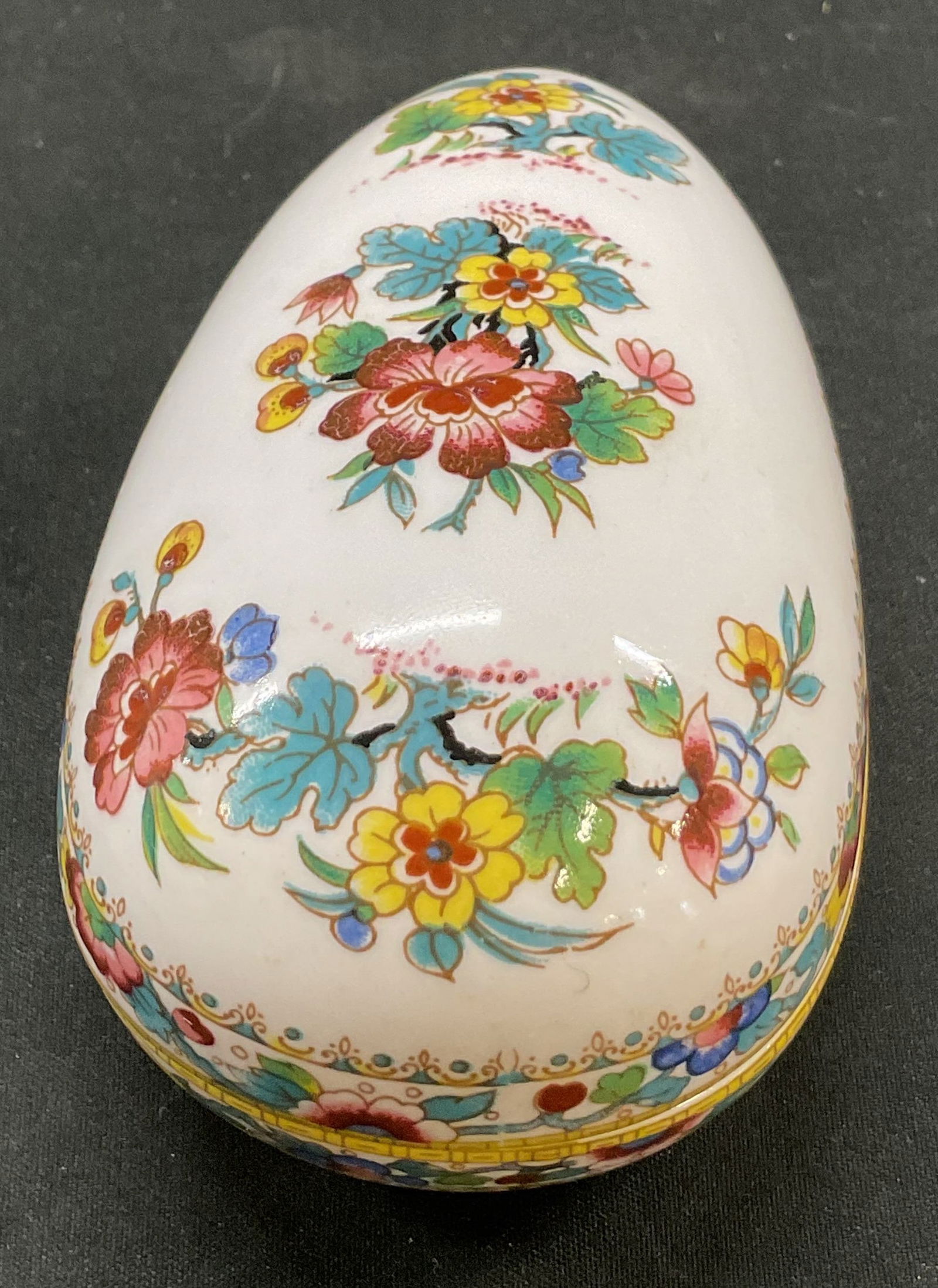 Coalport Bone China Ming Rose Trinket Bx England: Coalport bone china ming rose egg shaped trinket box. Marked on underside, reads Bone China Coalport Made In England Ming Rose. Egg shaped box. Floral motifs in varying colors, Ming Rose pattern. Meas