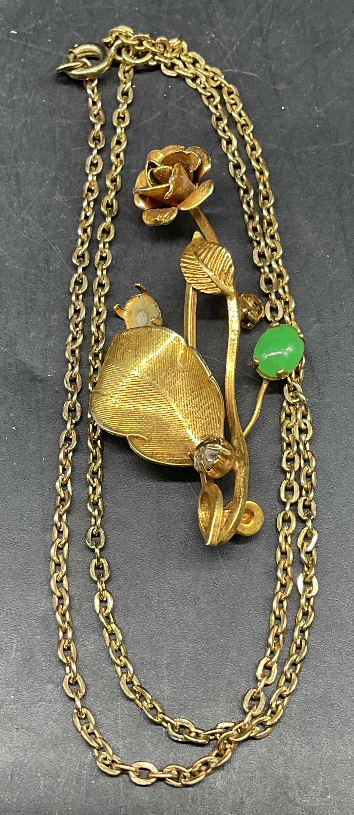 Lot 2 Gold Tone Flower Brooch & Chain Necklace: Lot of 2 jewelry pieces. Vintage gold tone chain necklace. Drop length measures approx. 8.75 inches. Vintage gold tone flower motif brooch with faux jade and crystal. Measures approx. 2.25 inches. Pin
