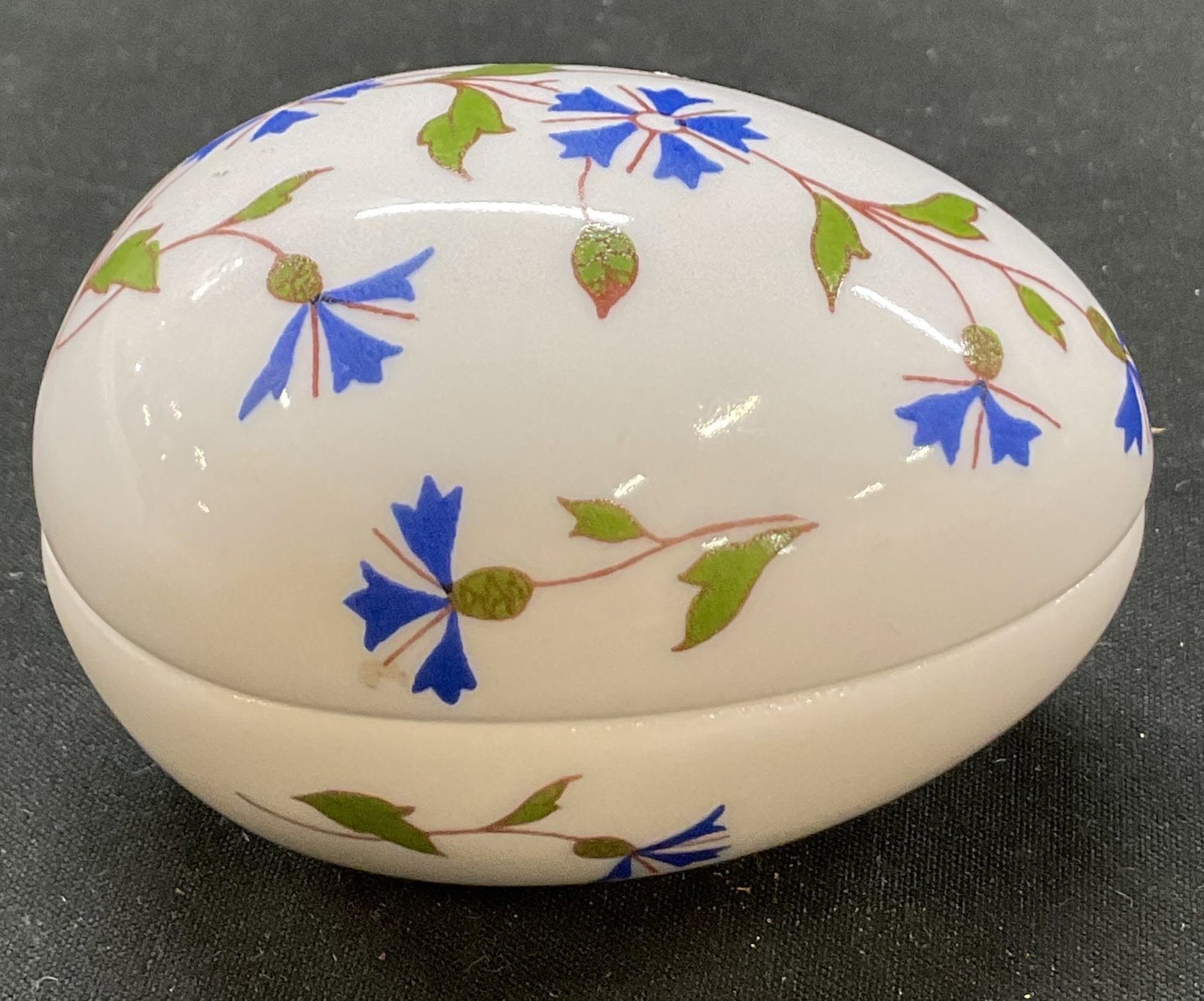 Limoges Egg Shaped Porcelain Trinket Box France: Limoges egg shaped porcelain lidded trinket box. Marked on underside, reads Chamart France Limoges. Floral motifs in green and blue, hand painted. Measures approx 2 x 3 x 2 inches. Surface wear consis