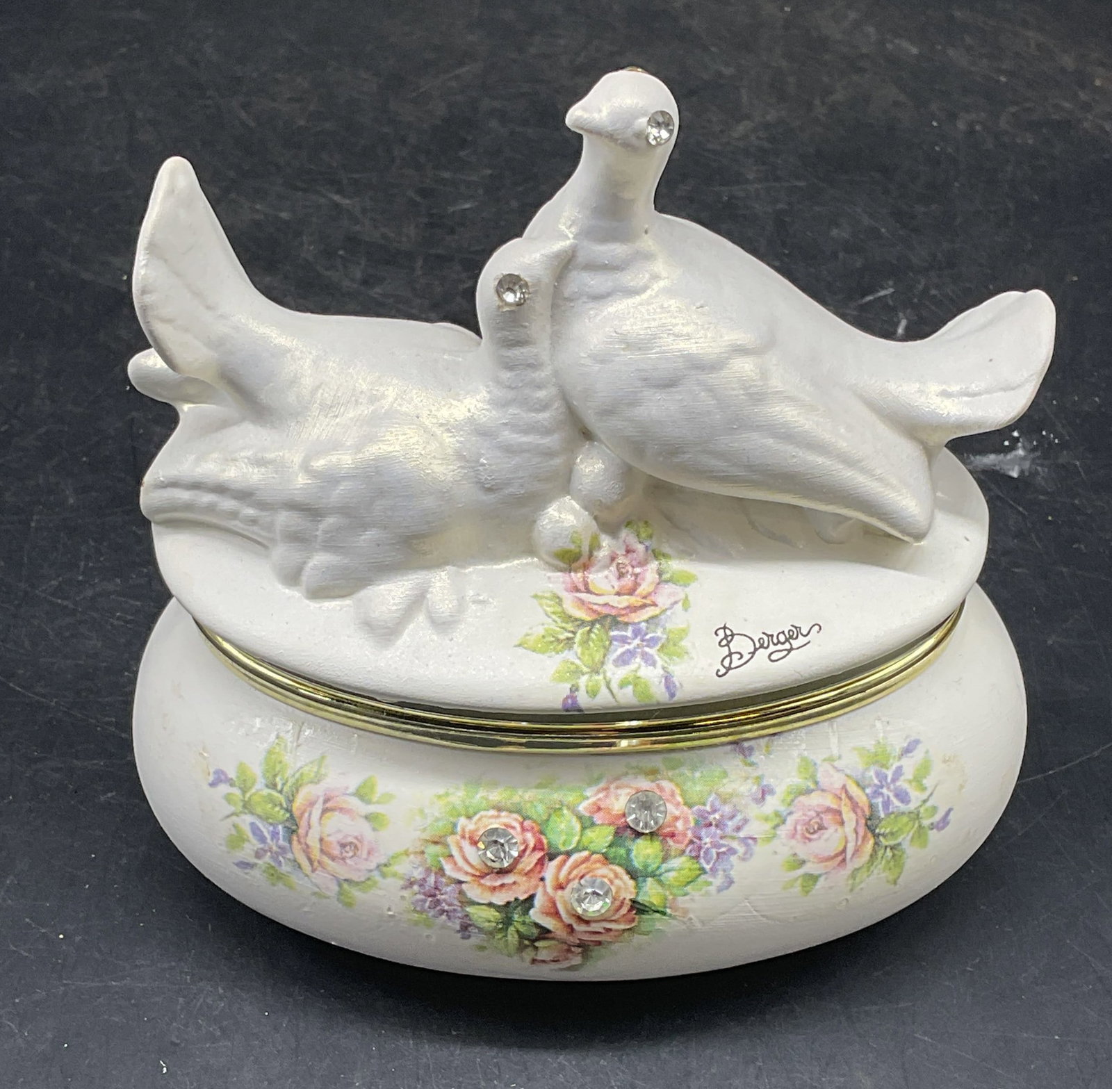 Berger Doves Porcelain Trinket Box, Italy: Signed Berge porcelain trinket box with doves lovebirds motif. Floral design with rhinestones. Made in Italy. Measures approx. 4.3 x 3 x 4.5 inches. Some scratching. Berger trinket box, dove trinket b