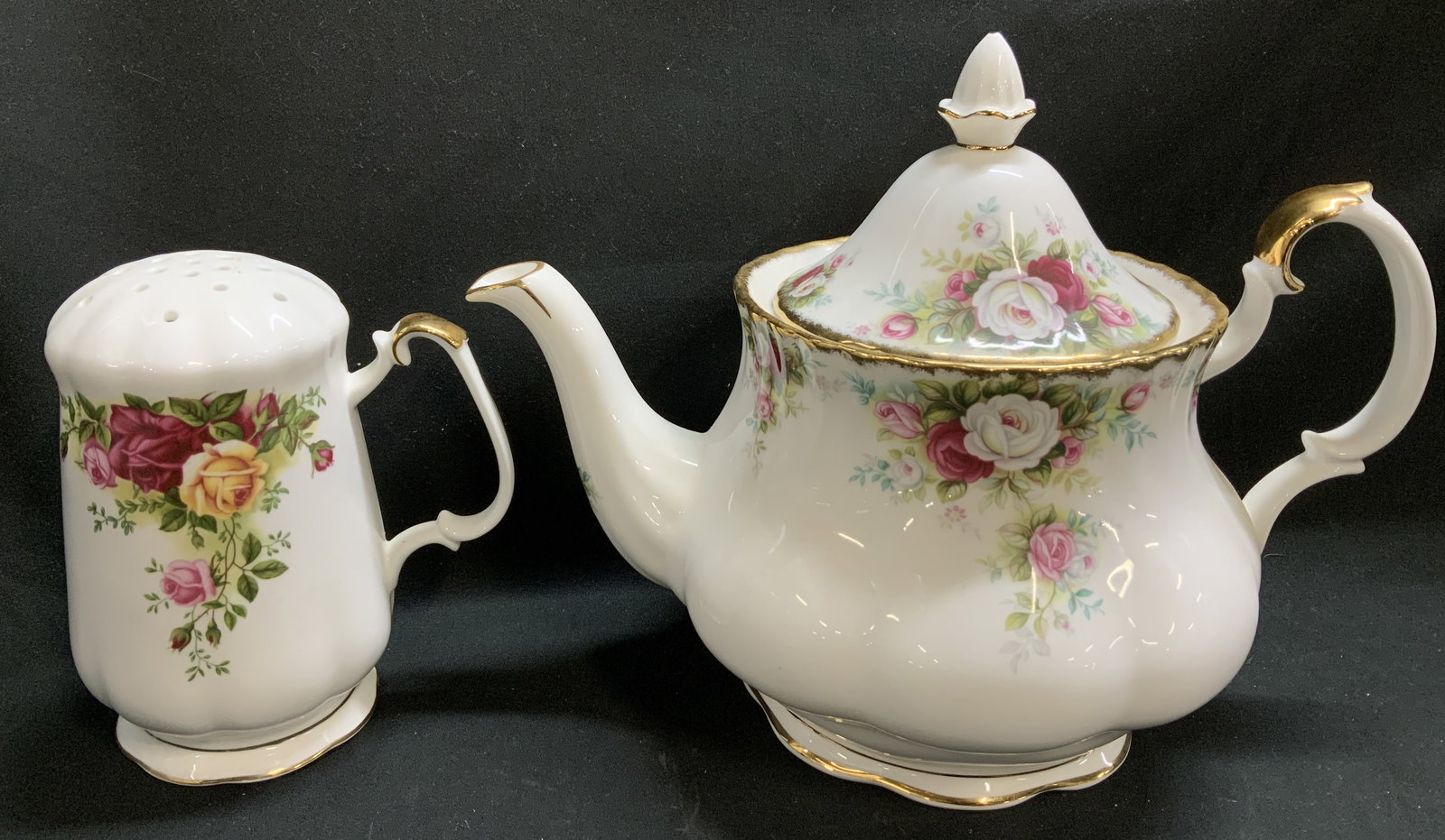 Lot 2 1962&1969 Royal Albert Teapot & Sugar Sifter: Lot includes, 1 sugar shaker sifter & 1 lidded teapot. Pieces are bone china material. Features an old country roses & celebration pattern. Vibrant floral motifs & gilt accents. Signed & marked. Reads