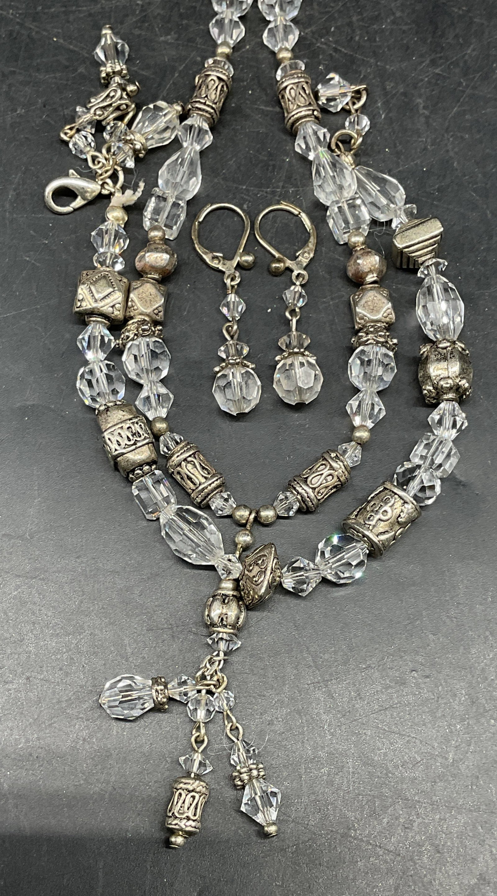 Lot 3 Silver Tn Crystal Necklace Bracelet +: Lot of 3 matching jewelry pieces. Necklace, bracelet, and earrings. Beaded silver tone and colorless crystals. Necklace drop length measures approx. 9 inches. Bracelet measures approx. 8 inches long.