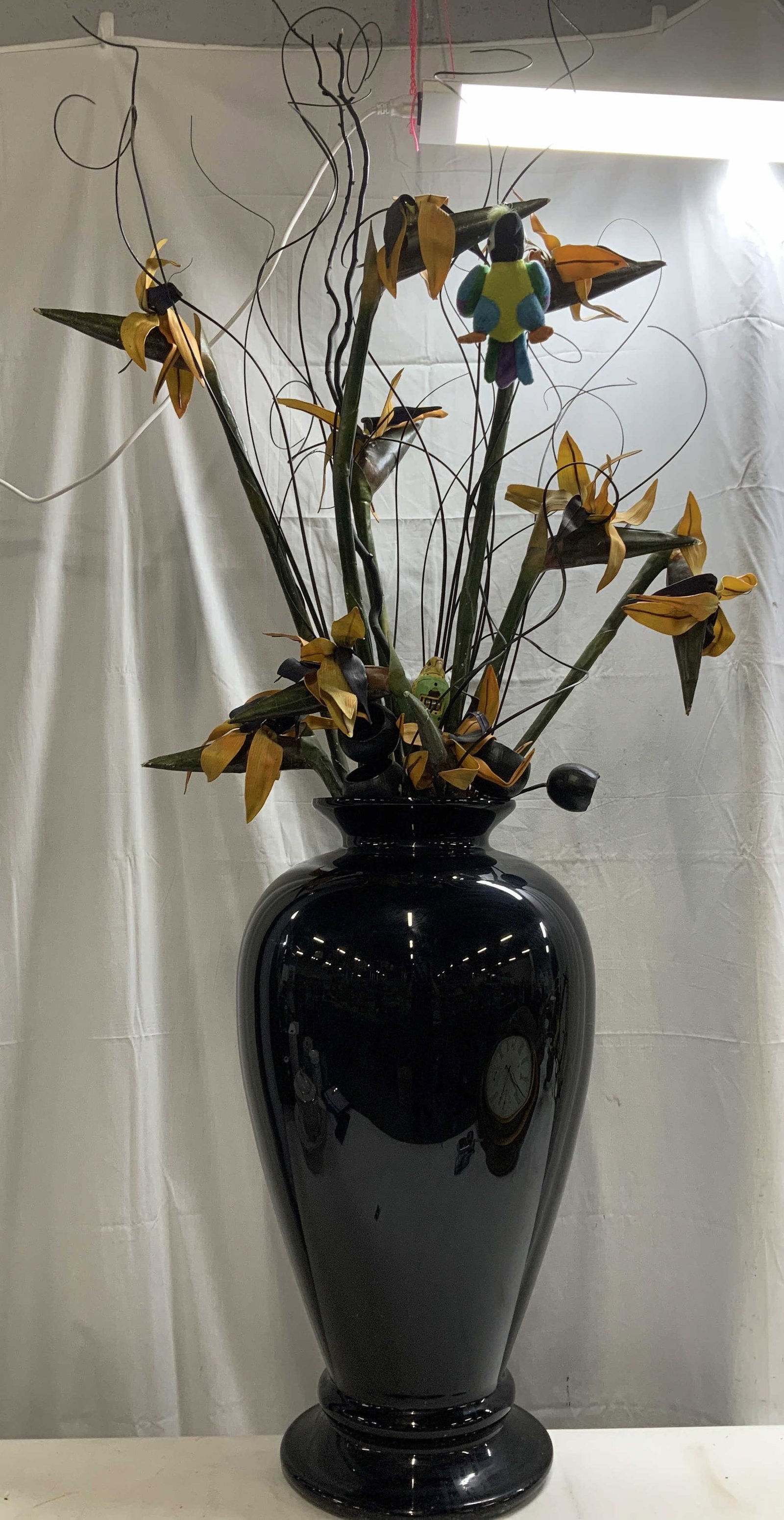 Large Vtg Black Ceramic Vase W Faux Flowers 63in: Lot includes, large vintage black ceramic vase featuring an urn shape & round base. Filled with faux floral arrangements. Plush & plastic bird motifs. Surface wear consistent to age, use & exposure. M