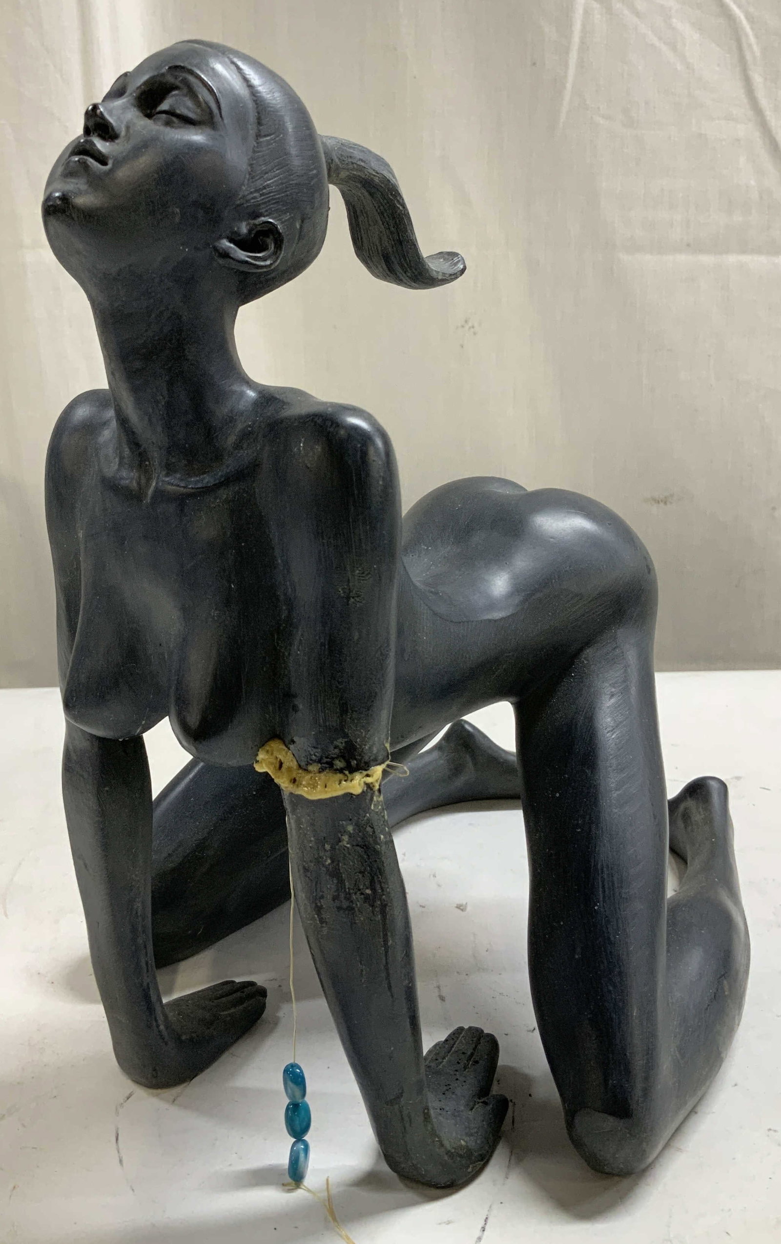 The Feline Stretch Balinese Sculpture: The Feline Stretch Balinese Sculpture depicting a nude female in a stretching pose. Composite material. No visible signature or markings. Surface wear consistent to age, use & exposure. Visible