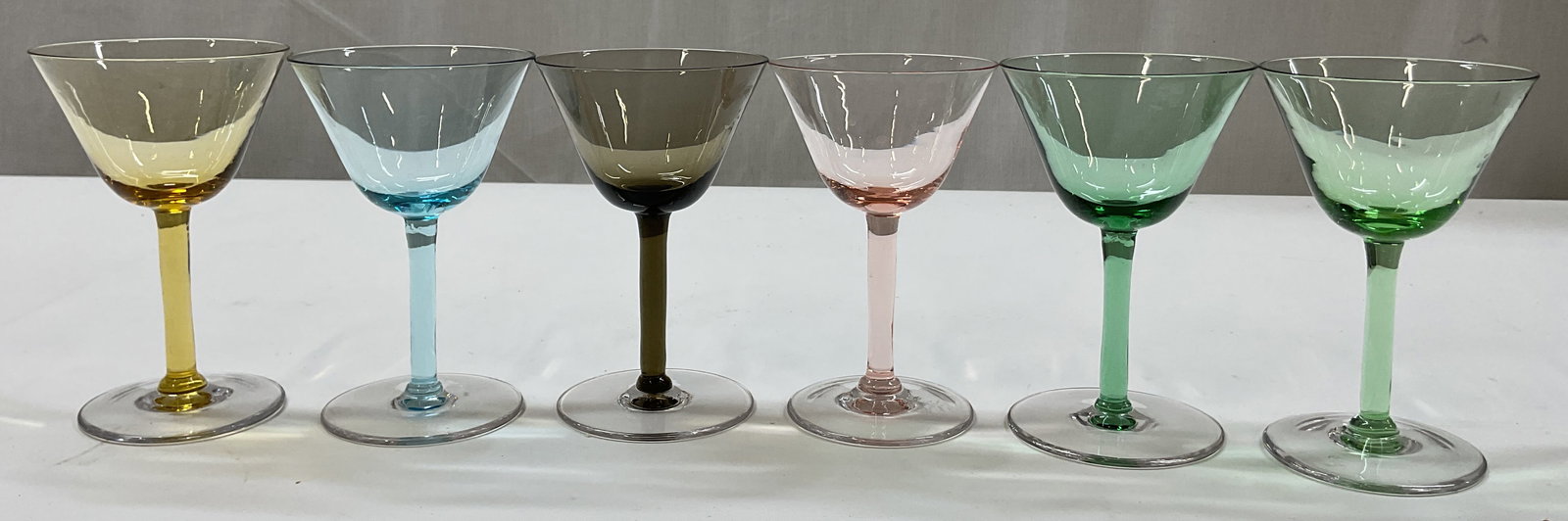 Set 6 Colorful Glass Martini Glasses: Set of 6 colorful glass martini glasses. Blues, green, yellows, etc. Round base and tall stem. Wide rim. Measures ht approx 5 inches base diam approx 3 inches. Surface wear consistent with exposure. S