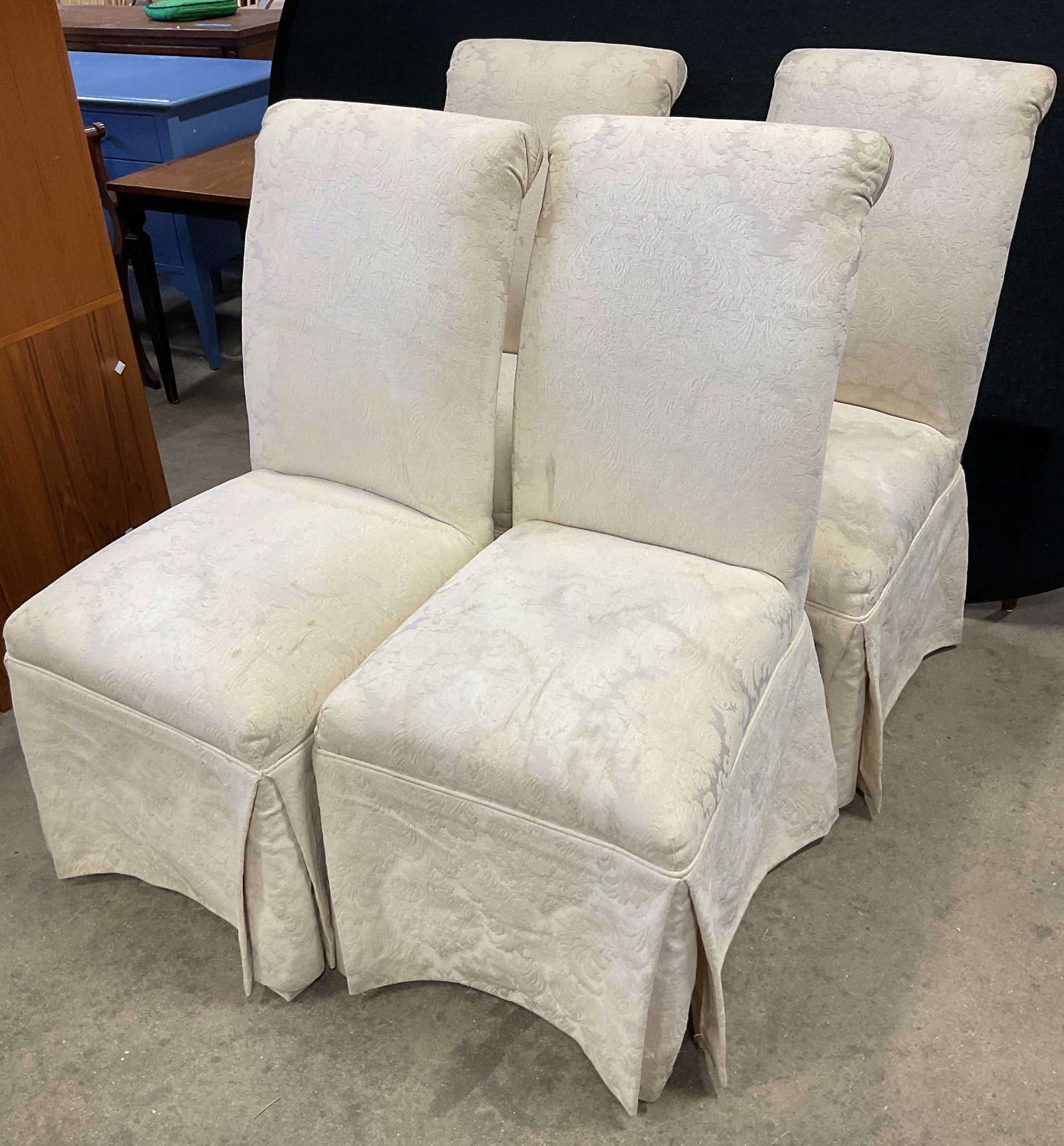 Set 4 Vtg Cream Upholstered Skirt Dining Chairs: Set of 4 vintage cream colored upholstered dining chairs. Tall backrest and cushioned seat. Floor length skirt that covers the legs. Textured floral motifs. Measures approx 21 x 21 x 39 inches. Blemis