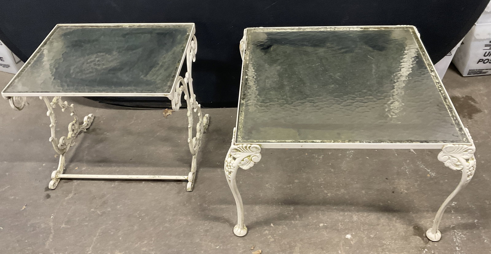 Lot2 VTG White Wrought Iron Glass-Top Tables: Lot of 2 VTG White Painted Wrought Iron Glass-Top Tables. Smallest has scroll design base. Largest has grape motif base. Surface wear to glass and metal present. Largest measures app 16in H x 24.5in L