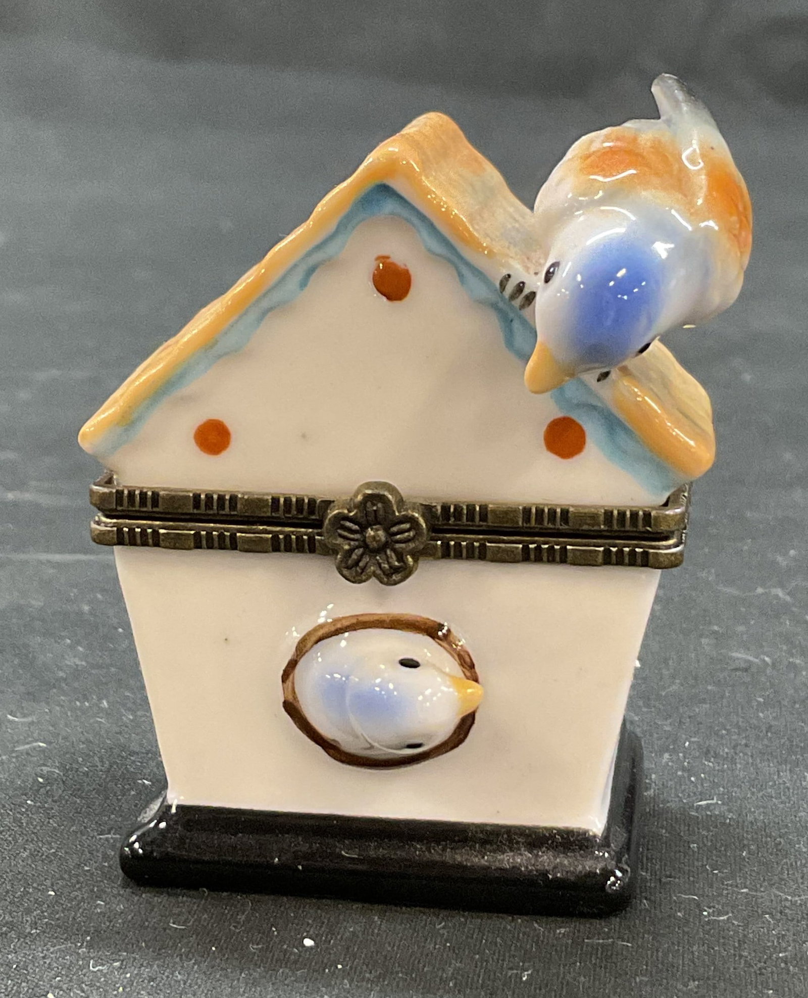 Vintage Porcelain Birdhouse Hinged Trinket Box: Vintage porcelain birdhouse hinged trinket box. Marked on underside, made for Direct Connection Industry CA. Birdhouse shaped box with two bird motifs. Hand painted in varying colors. Detailed feature