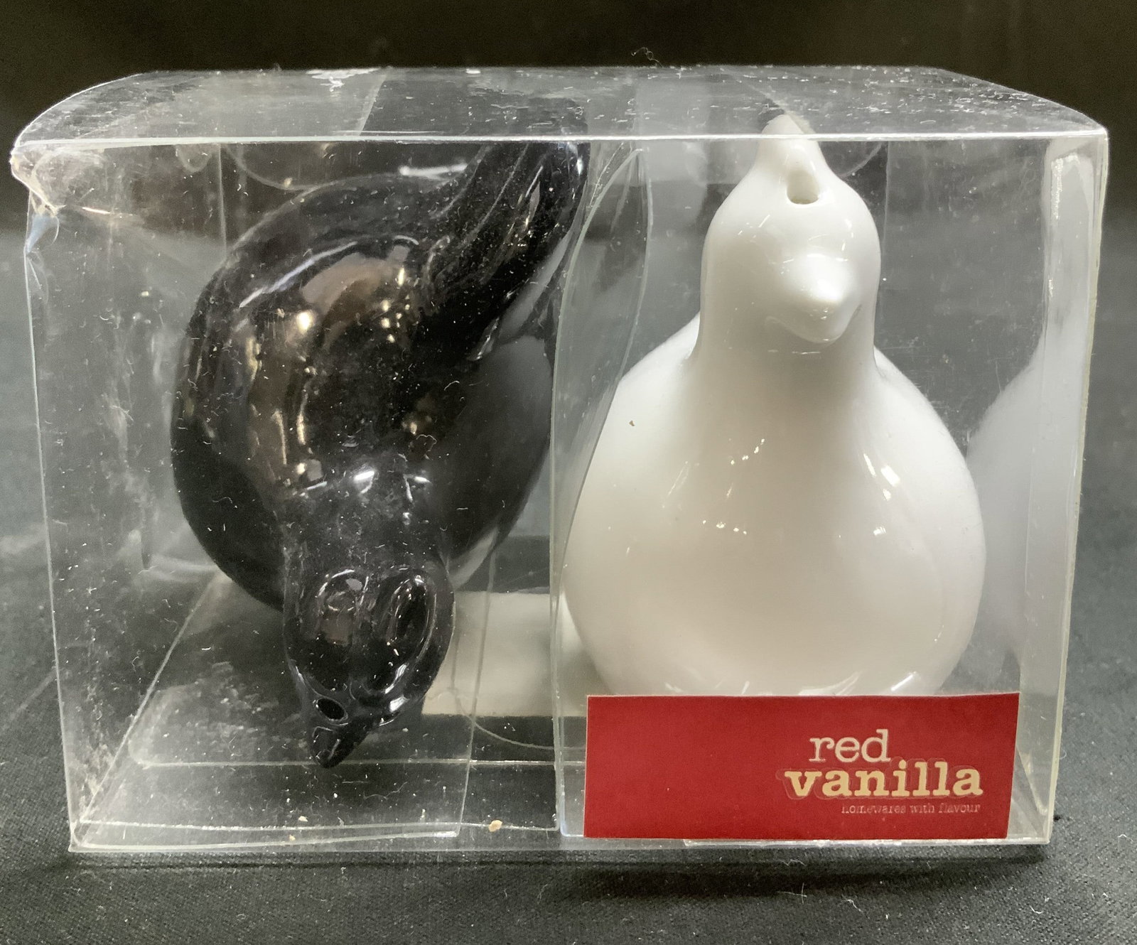 Red Vanilla Homewares Chicken S&P Shakers NIP: Lot includes, salt & pepper shakers shaped like chickens. Black & white toned. Porcelain material. Signed & marked on underside. Reads, By Red Vanilla Homewares with Flavour. Surface wear consistent t