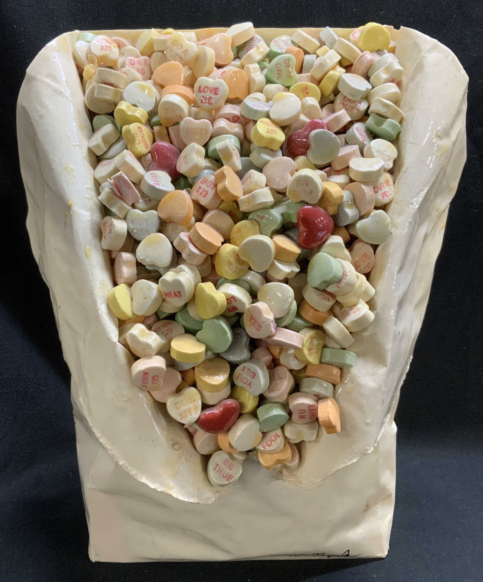 Tom Pergola Sweet Love Sculpture 10in: Tom Pergola sculpture titled, Sweet Love. Depicts a crumbled bag with Valentines Day heart candies. Glossy finish. Composite material. Surface wear consistent to age, use & exposure. Visible