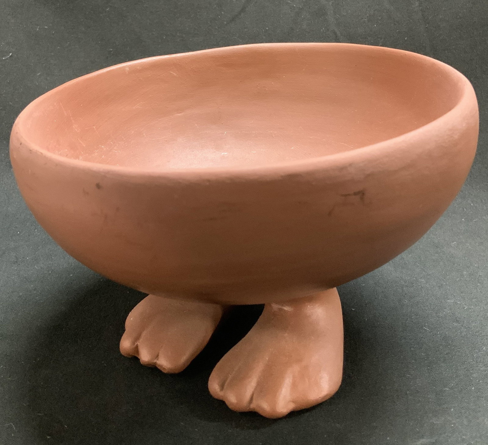 Metropolitan Museum of Art Pottery Bowl: Metropolitan Museum of Art (MMA) pottery bowl featuring human feet on underside. Signed & marked on underside. Reads, MMA. Surface wear consistent to age, use & exposure. Measurements: length 5.5in x