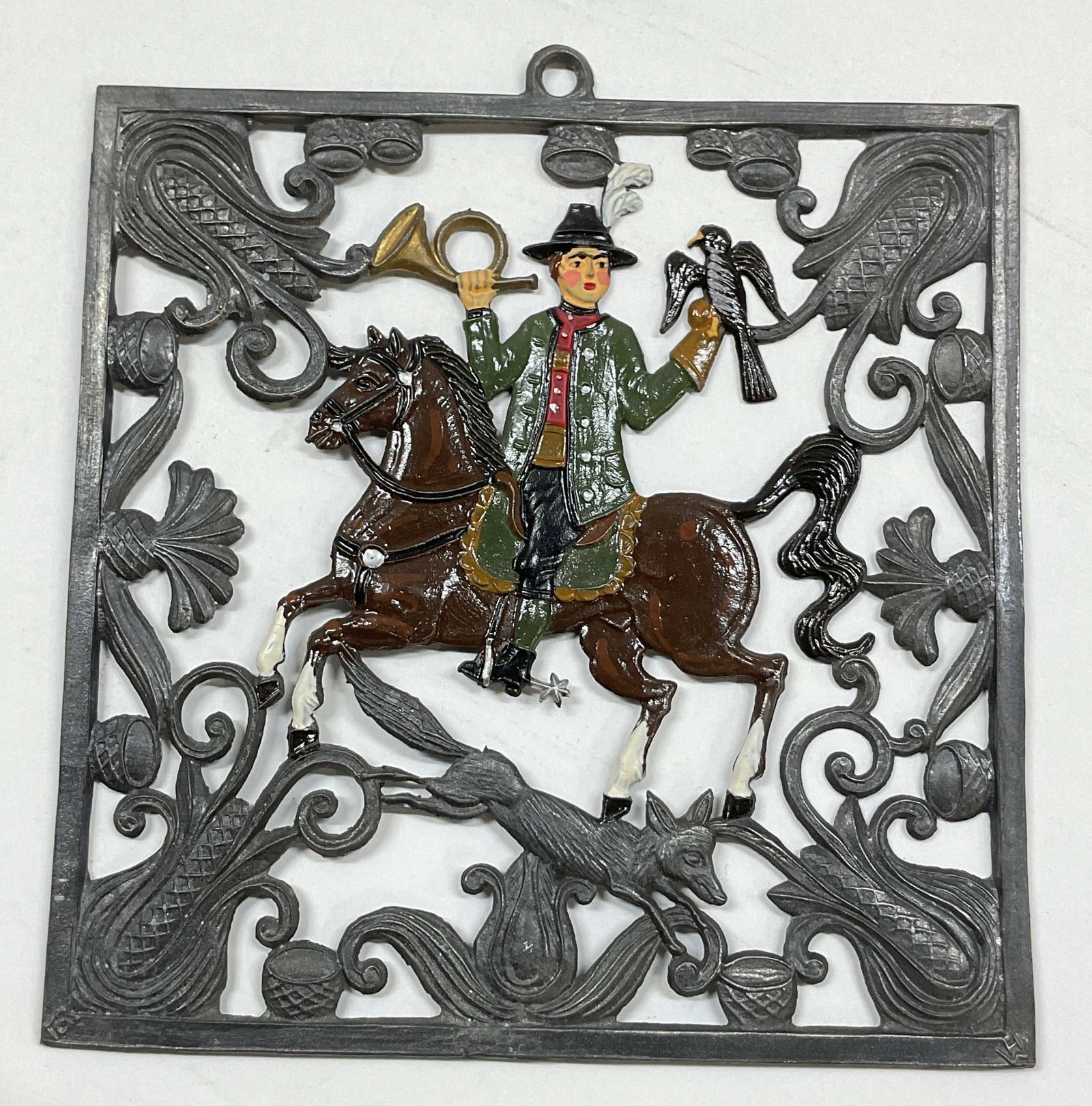 Babette Schweizer Pewter Horseman Wall Plaque: Babette Schweizer pewter horseman wall plaque. Features a hunter on a horse holding an instrument and falcon. Hand painted in varying colors. Ornate embossed floral, fox, and scroll motifs. Detailed