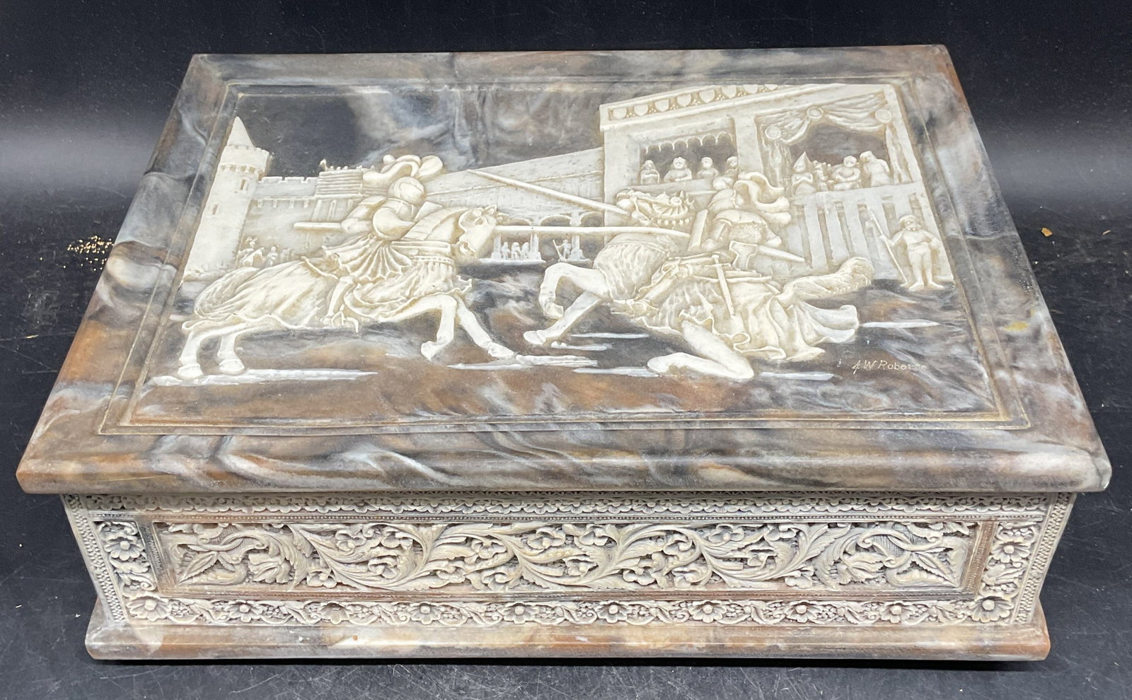 Incolay Stone Jousting Knights Jewelry Box USA: Carved genuine Incolay stone jewelry box. Ornate scroll panels with jousting knights motif lid, removable interior top tray, velvet lined compartments. Made in USA. Measures approx. 11.75 x 9 x 3.75 i