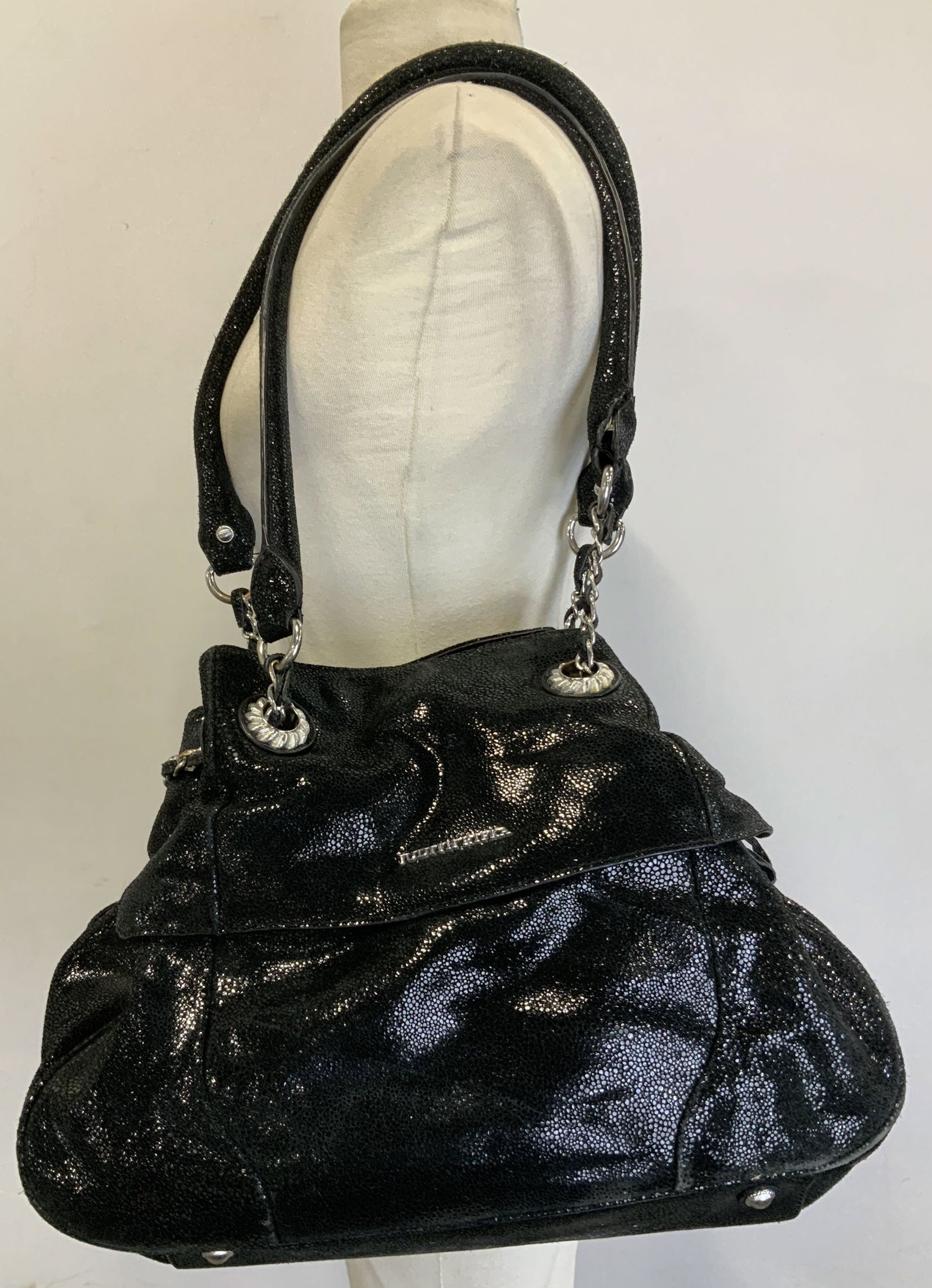 Judith Ripka Black Leather Handbag: Judith Ripka black leather handbag with silver toned hardware. Tassel accents on sides. Signed & marked. Reads, JUDITH RIPKA. Surface wear consistent to age, use & exposure. Measurements: height of bo