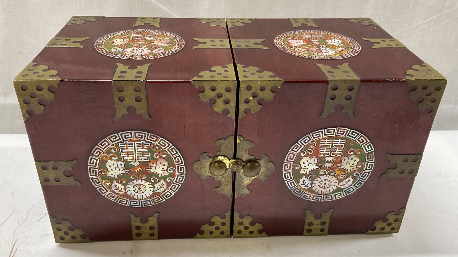 Asian Lacquered Wood Pearl Inlay Jewelry Box: Asian Lacquered Wood Mother-Of-Pearl Inlay Folding Jewelry Box. Reddish Brown with Circular Pearl Inlay Designs on Front and Top. Folds Open to Reveal Four Drawers with Red Velvet Lining. Condition