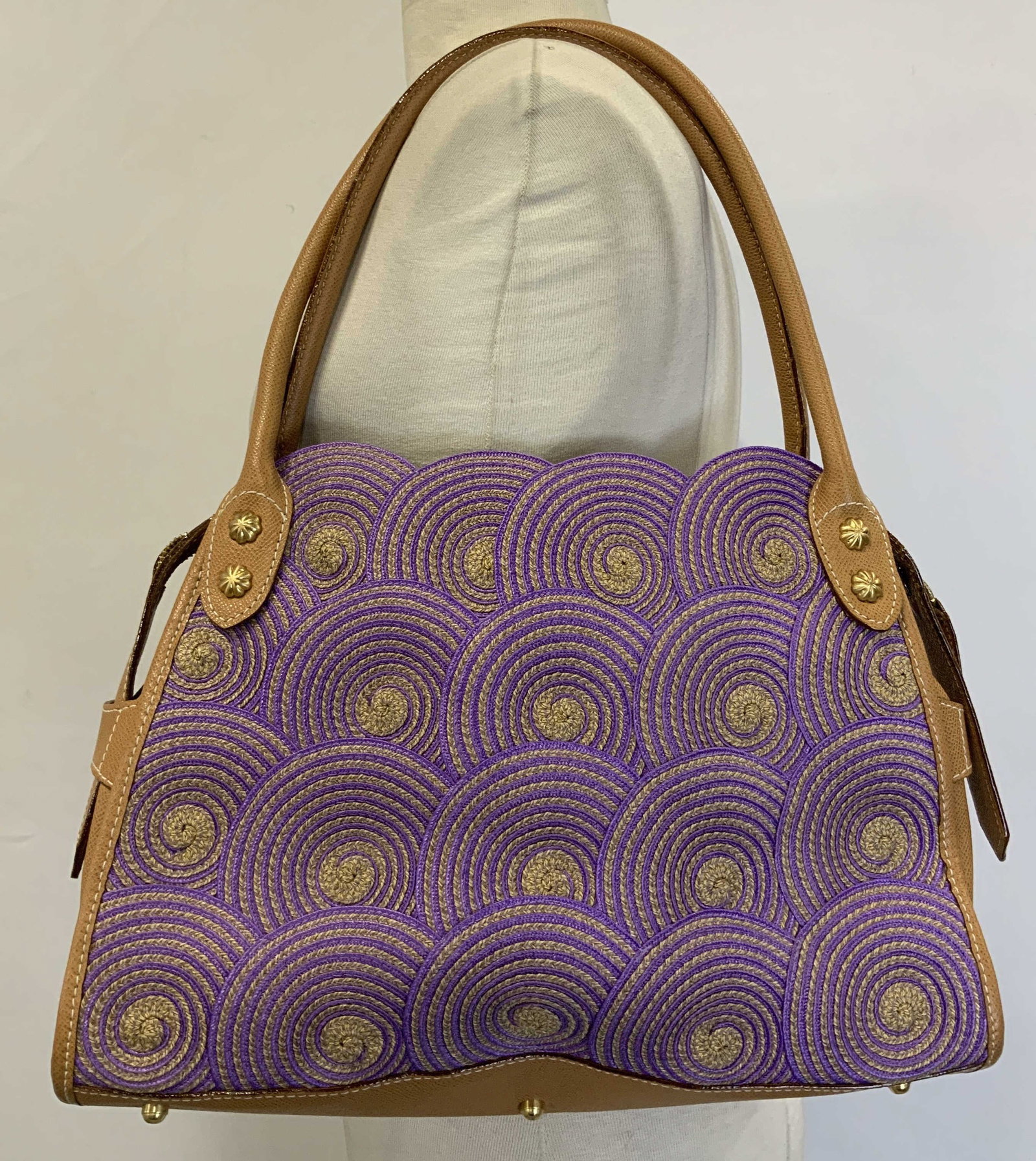 Eric Javits Leather Handbag New York: Eric Javits handbag is purple & brown toned. Leather material. Distinctive swirls on body. Interior has clear pockets. Signed & marked. Reads, ERIC JAVITS NEW YORK. Surface wear consistent to age, use