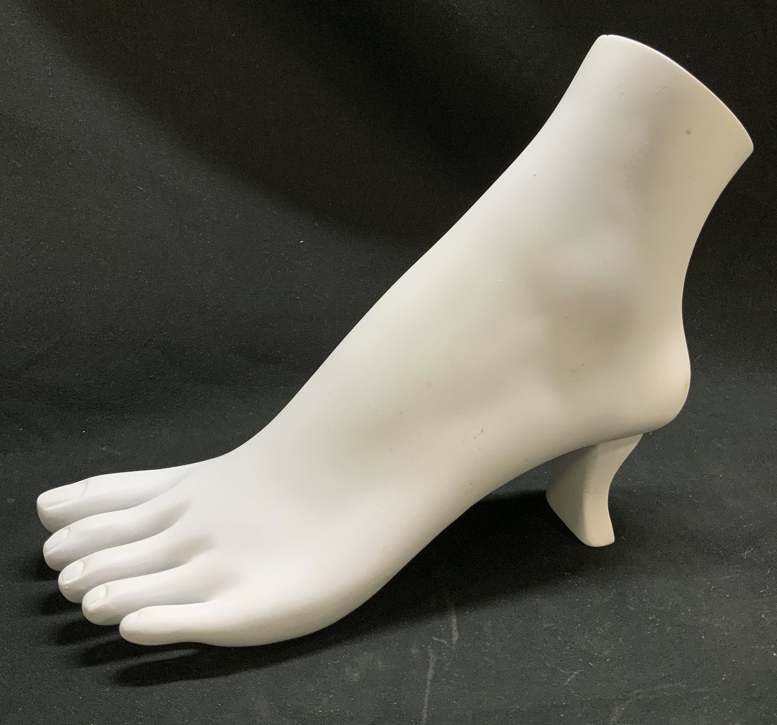 Jewelry Display Mannequin Foot: Jewelry display shaped as a mannequin foot. Holds anklets, toe rings, & ankle chains. High heel design. White toned. Surface wear consistent to age, use & exposure. Measurements: length 9in x width 3.