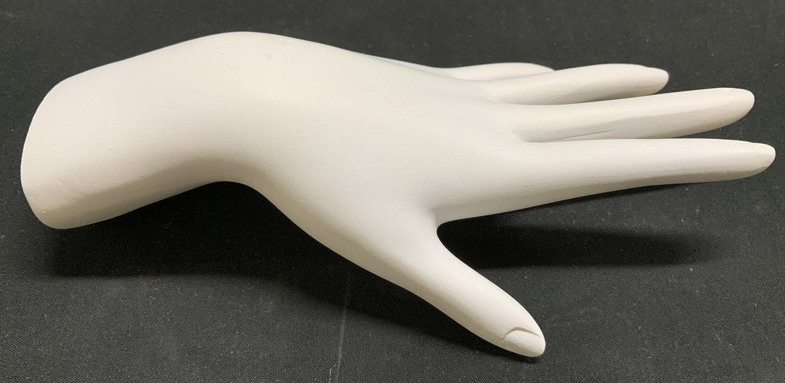 Jewelry Display Mannequin Hand: Jewelry display shaped as a mannequin hand. White toned. Holds rings & bracelets. Surface wear consistent to age, use & exposure. No visible signature or markings. Measurements: length 8in x width 4in