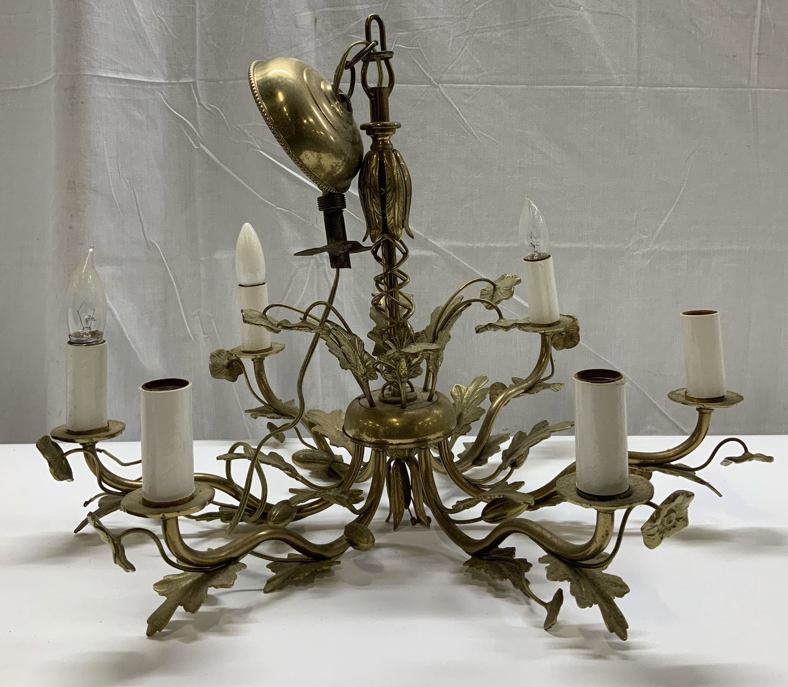 Vtg Hollywood Regency Brass Chandelier: Vintage Hollywood Regency style brass chandelier with leaf & vine motifs. 6 sweeping arms. Hanging chain at top. Surface wear consistent to age, use & exposure. No visible signature or markings. Measu