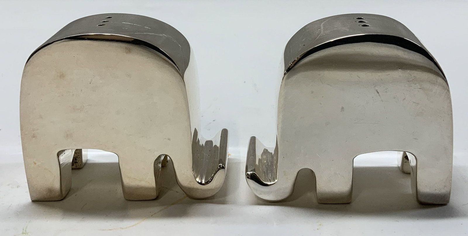 Elephant Silver Toned Salt & Pepper Shakers: Silver toned salt & pepper shakers shaped as elephants. Distinctive trunk. No visible signature or markings. Surface wear consistent to age, use & exposure. Measurements: length 2.2in x width 1.2in x 