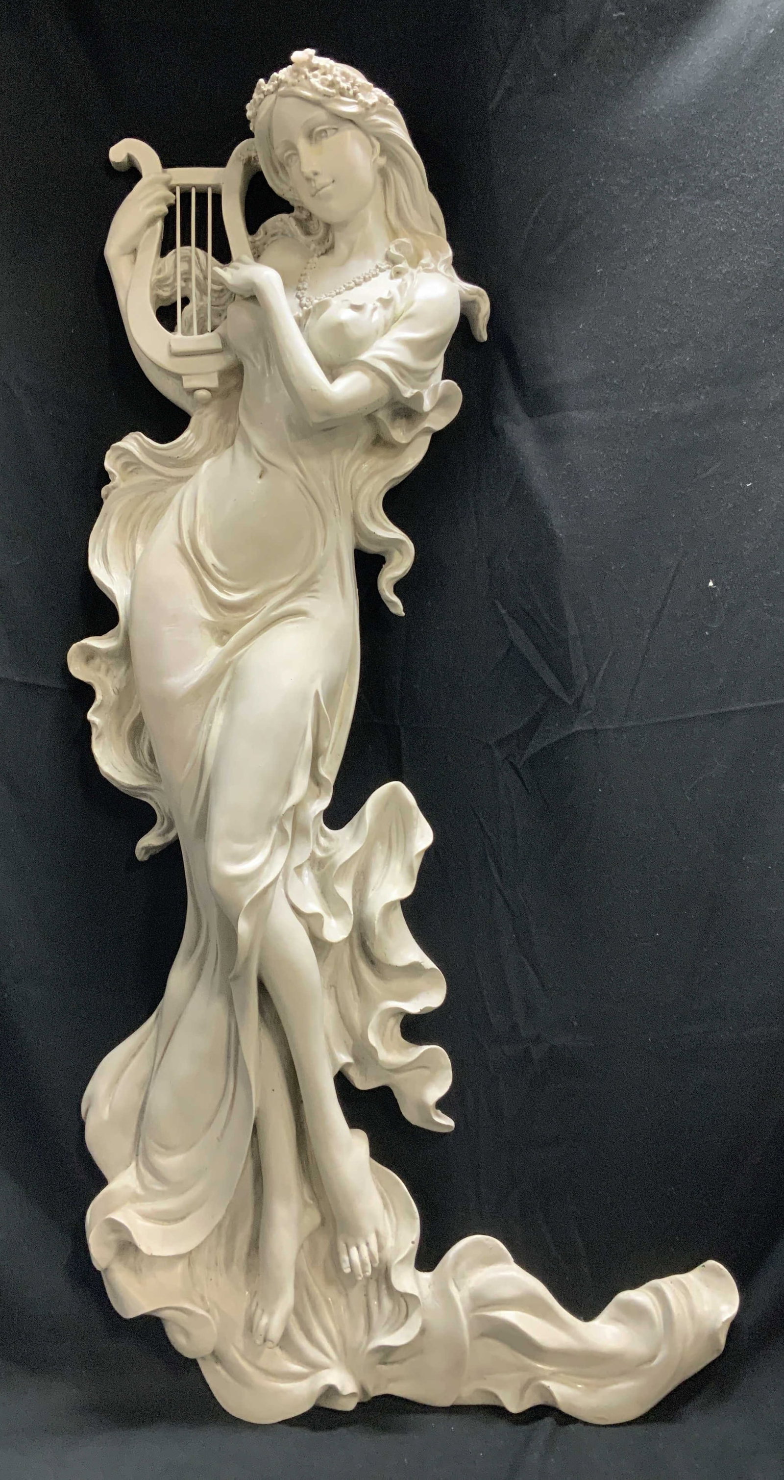 Musical Muse Wall Sculpture 30in: Wall sculpture depicting a muse playing a lyre. Intricate detailing & grey/white toned. Resin material. Surface wear consistent to age, use & exposure. Measurements: height 30in x 14.2in width. Musica