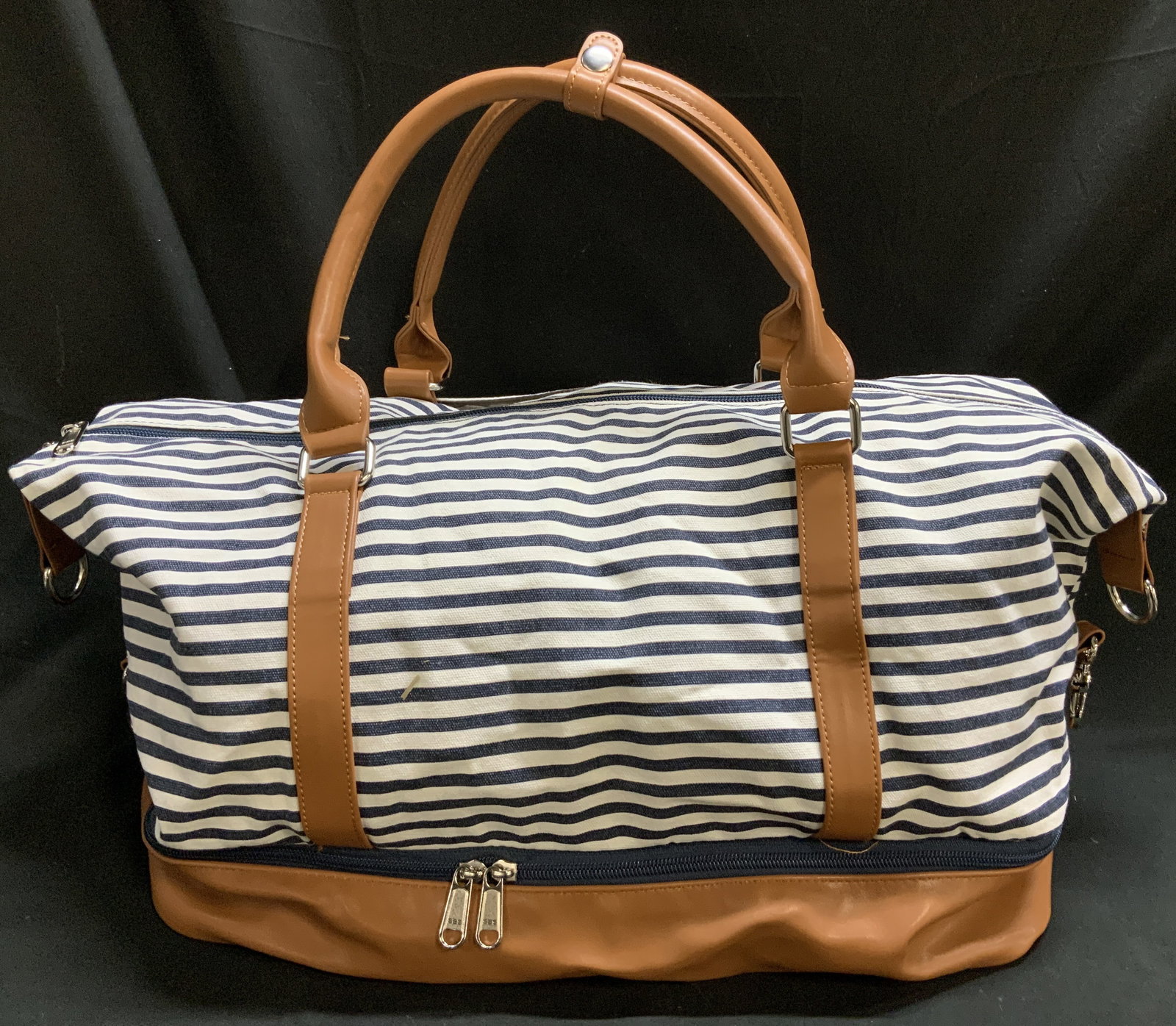 SBS Canvas & Faux Leather Duffle Bag: SBS duffel bag features faux leather accents & a striped canvas body. Silver toned accents. Surface wear consistent to age, use & exposure. Measurements: length 29in x width 10.2in x height to handles