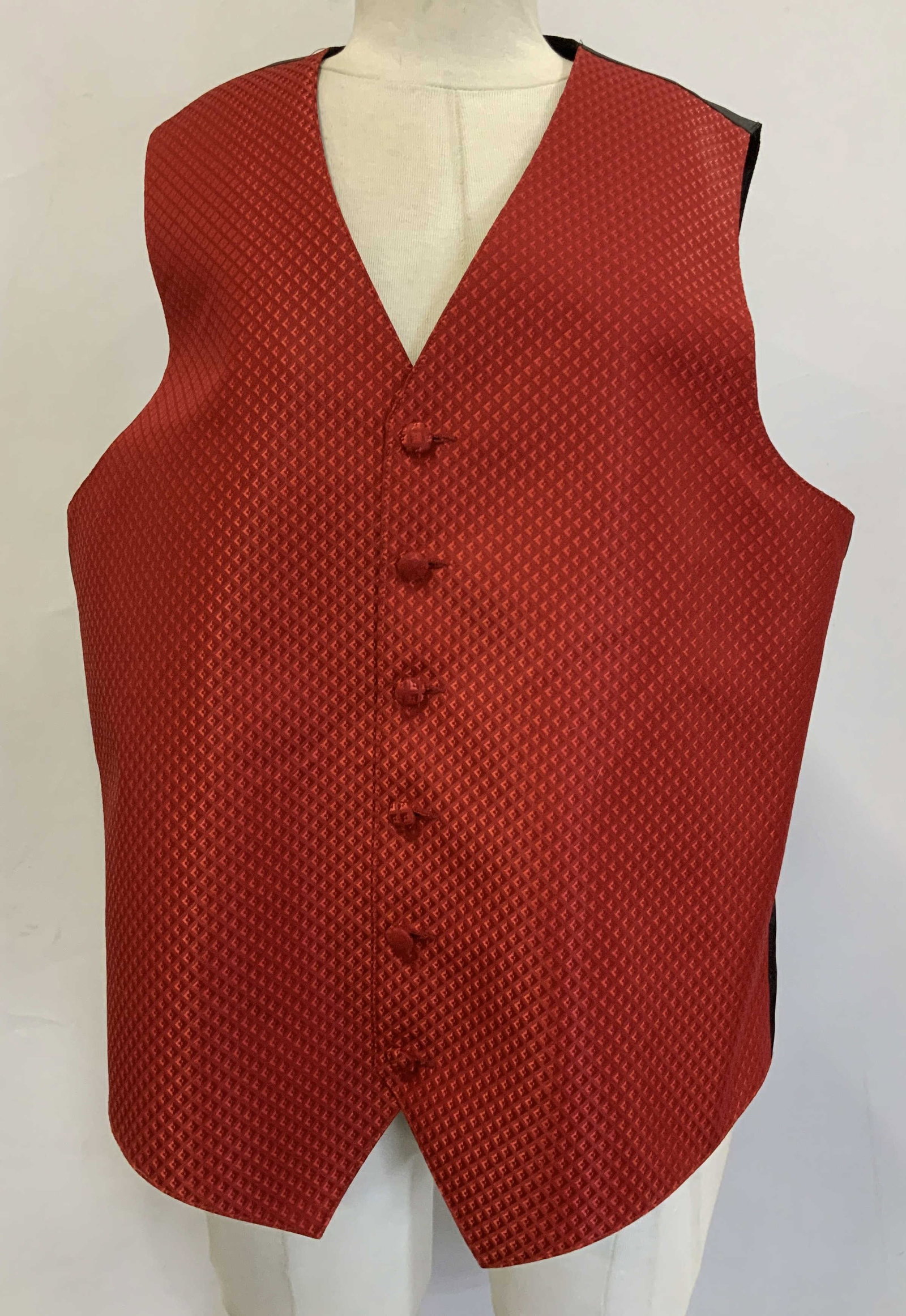 Red & Black Tuxedo Vest USA: 100% polyester. Size M. Red patterned tuxedo vest featuring a V neck design & 6 button front closure. Signed & marked. Reads, MADE IN USA. Surface wear consistent to age, use & exposure. Red & black t