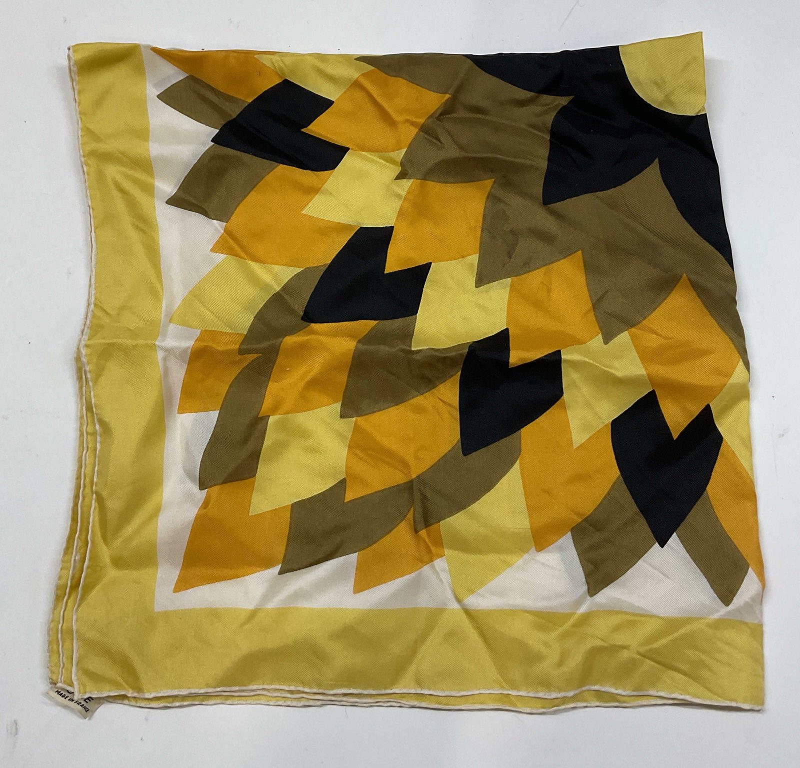 Vintage Floral Silk Scarf France: Vintage floral silk scarf. Silk material. Made in France. Central floral motif in black, yellow, green, orange, and more. Yellow border. Measures approx 25 x 26 inches. Some blemishes. Scarf, silk sca