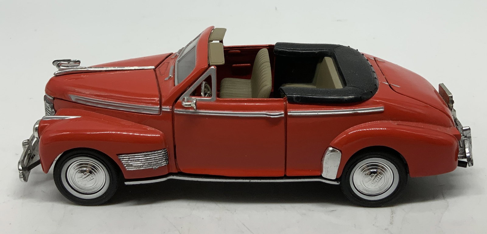 1941 Chevrolet Deluxe Die Cast Model: 1941 Chevrolet Deluxe die cast model features a red & silver toned exterior. Doors & hood open. Surface wear consistent to age, use & exposure. Signed & marked on underside. Reads, 1941 Chevrolet Delu