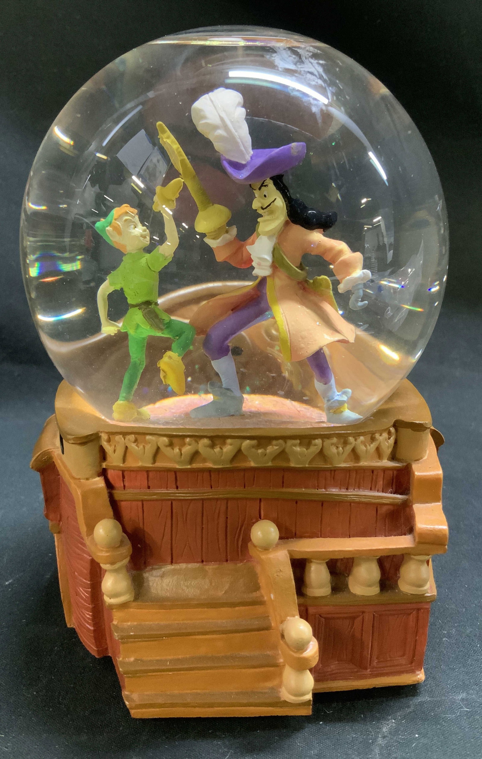 Disney Peter Pan Pirate Ship Musical Snow Globe: Disney Peter Pan Pirate Ship Showdown musical snow globe, featuring Captain Hook & Peter Pan in a sword fight on the deck of the Jolly Roger. Signed & marked on underside. Reads, DISNEY YOU CAN FLY. W