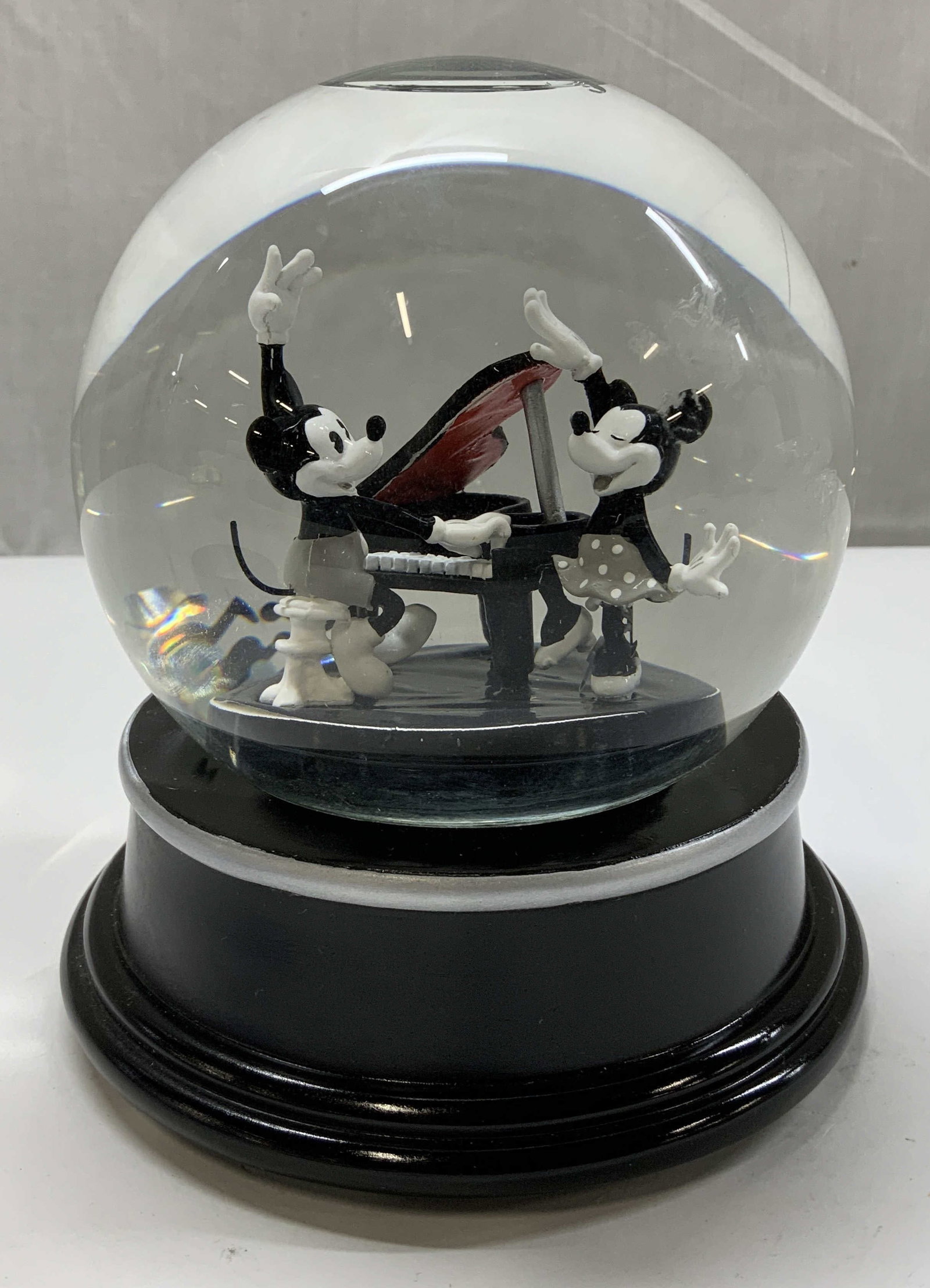 Disney Anniversary Edition Musical Snow Globe: Disney Anniversary Edition musical snow globe depicting Mickey & Minnie playing a piano. Black & white toned. Resin material. Plays, Turkey in the Straw. Signed & marked on underside. Reads, INTRODUCI