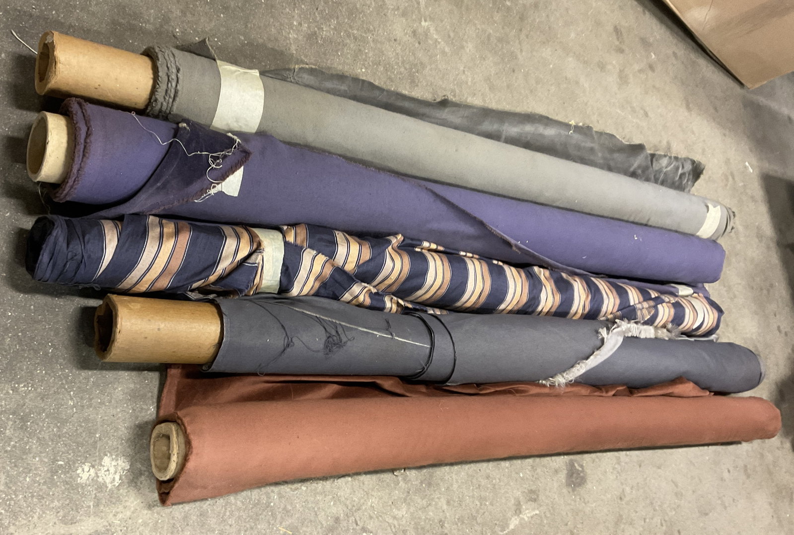 Lt 5 Solid and Striped Bolts of Fabric: Lt 5 Solid and Striped Bolts of Fabric. Mixed Materials. Velvet, Cotton, and More. Solid and Striped Patterns. Purple, Grey, and Brown. Not Measured, Unrolled, or Inspected. Sold As Is. Part of Large 