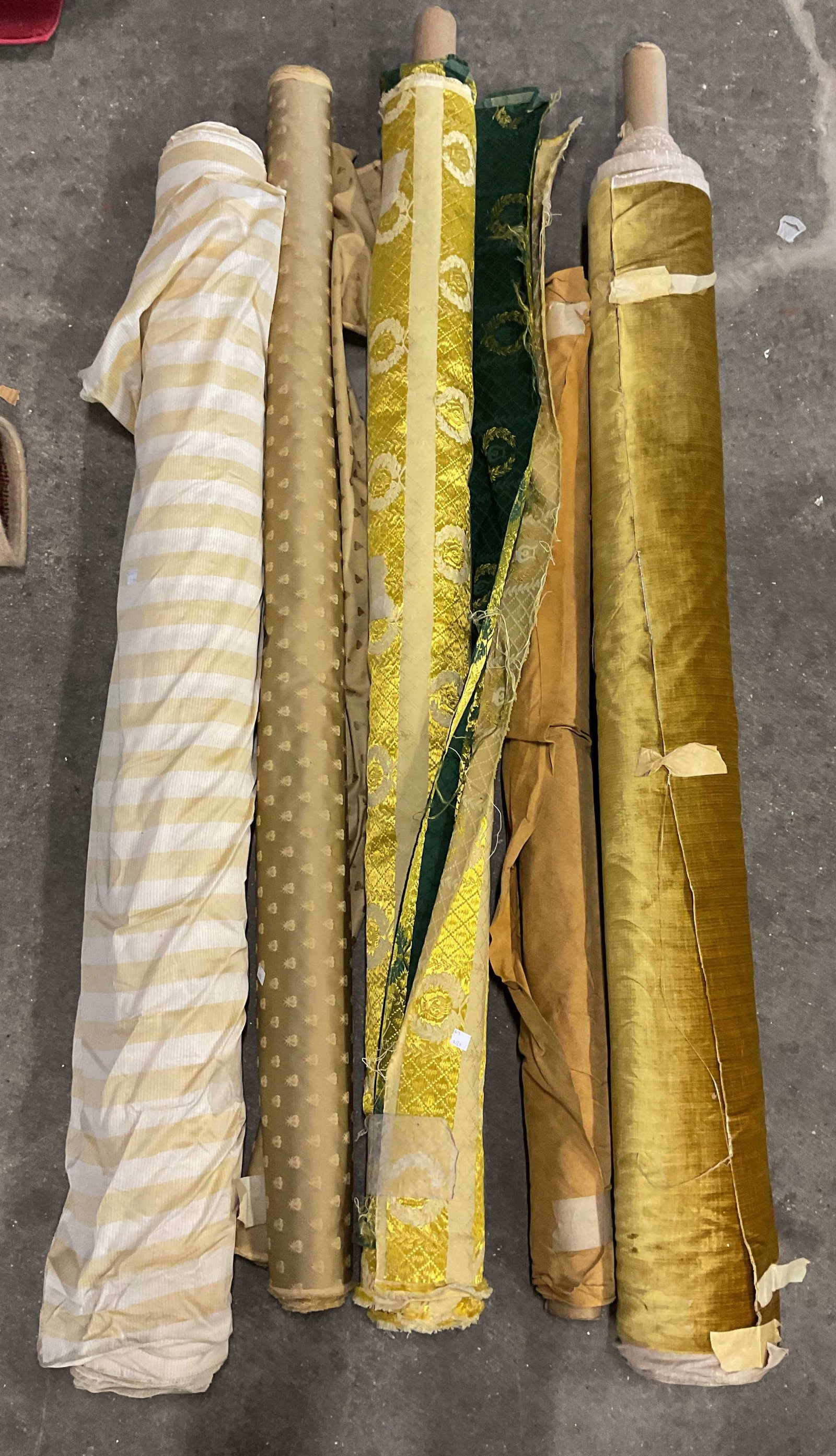 Group Lot 6 Gold Yellow Designer Fabric Bolts: Lot of 6 designer fabric bolts. Cotton, silk velvet, suede style, and more. Striped, scroll, beetle, and solid prints. Gold, yellow, and green. Not Measured, Unrolled, or Inspected. Sold As Is. Part o