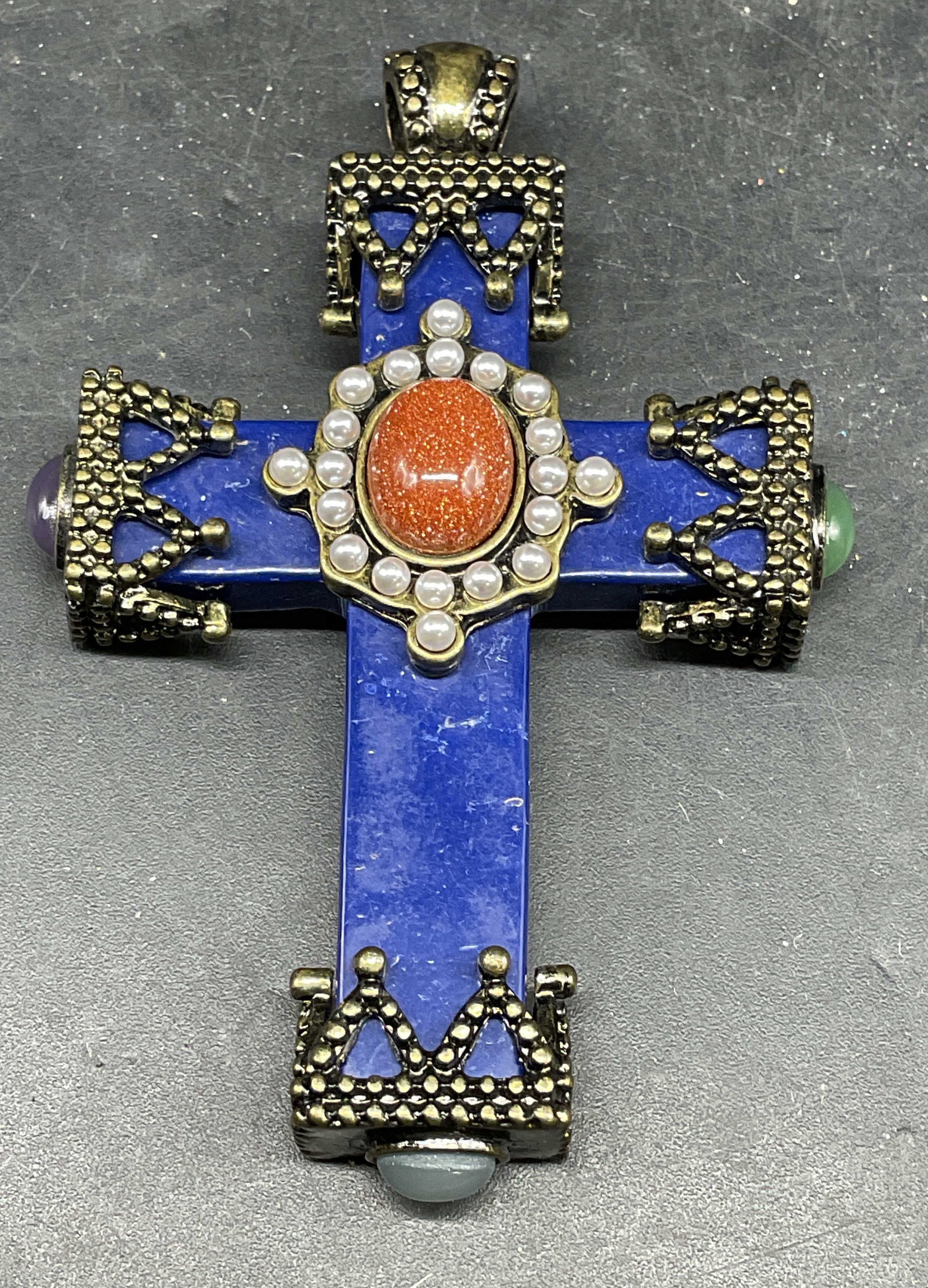 Blue Semiprecious Stone Cross Pendant: Blue semiprecious stone cross pendant with gold tone accents, multicolor glass cabochons, and faux seed pearls. Measures approx. 2.25 x 1.75 inches. Some scratching. Jewelry, estate jewelry, costume j