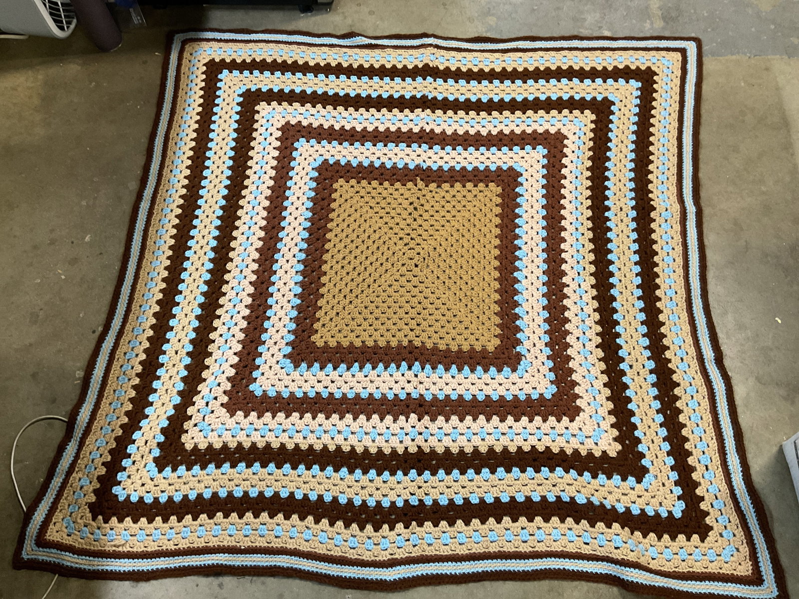 Vtg Hand Made Crocheted Brown Throw Blanket: Vintage hand made crocheted brown throw blanket. Striped geometric pattern in brown and blue. Measures approx 46 x 47 inches. Surface wear consistent with exposure. Throw blanket, blanket, decor, home