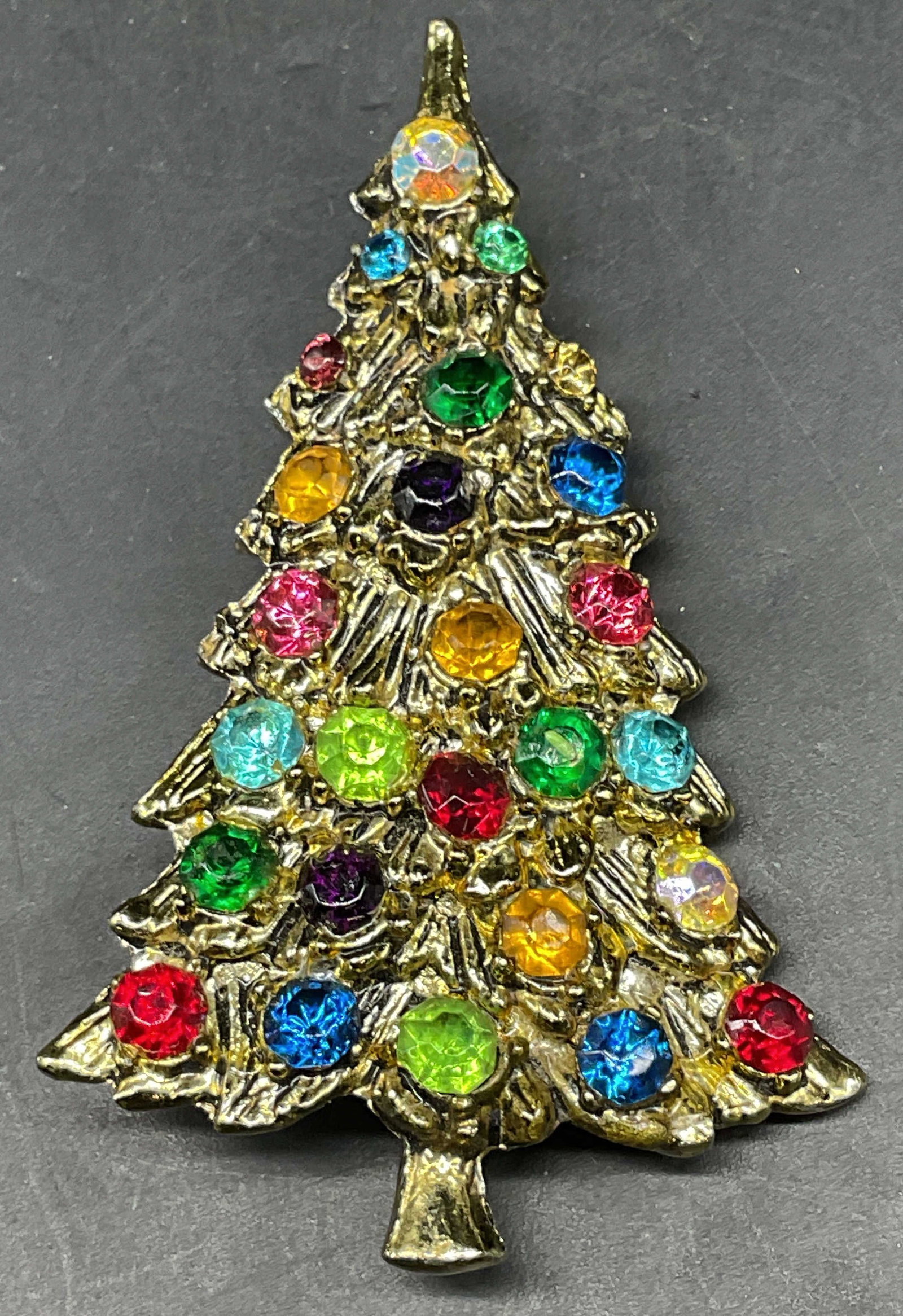 Vtg Gold Tone Crystal Christmas Tree Brooch: Vintage gold tone multicolor crystal Christmas tree motif brooch. Measures approx. 2.5 x 1.75 inches. Some crystals need replacement. Some scratching. Jewelry, estate jewelry, costume jewelry, cocktai