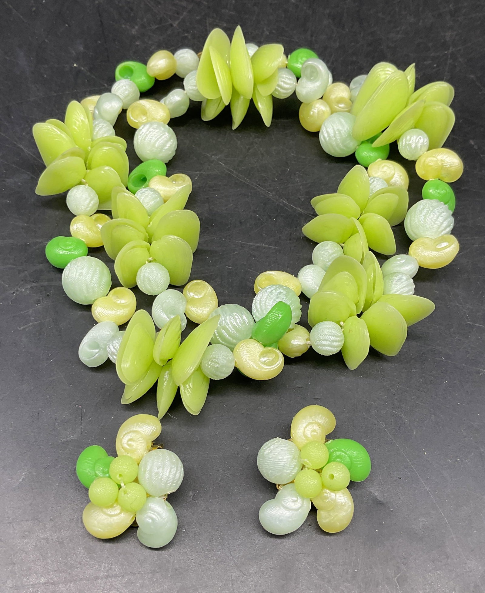 2 Green Shell Motif Necklace & Earrings W Germany: Set of 2 matching vintage green shell motif beaded necklace and earrings. Made in West Germany. Earrings measures approx. 1 inch long. Necklace drop length measures approx. 10 inches long. Some scratc
