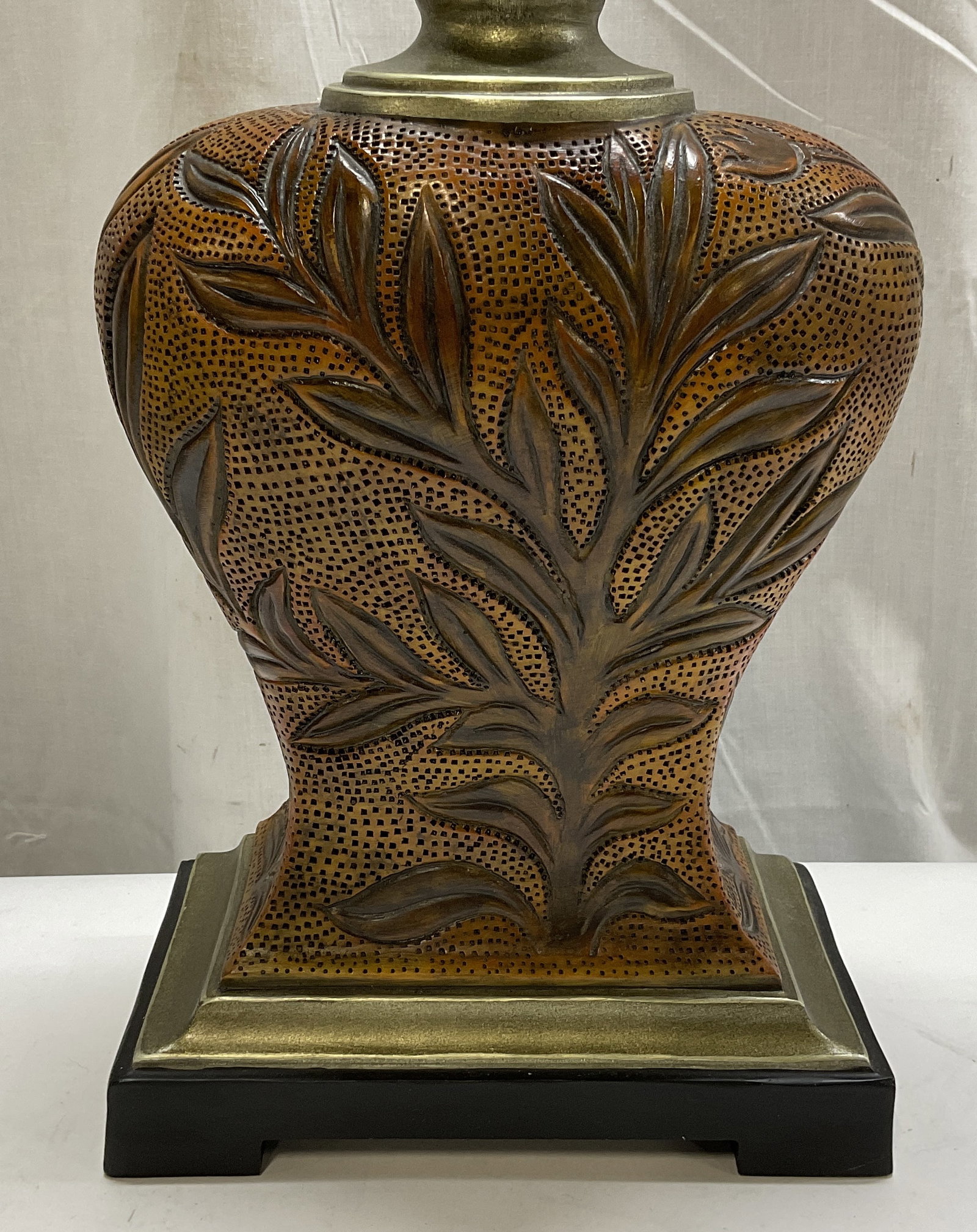 Brown Mottled Carved Leaf Urn Base Table Lamp: Brown Mottled Carved Leaf Urn Base Table Lamp. Made of Resin. Painted Gilt and Black Stand. Condition Consistent with Exposure. Has Not Been Tested For Functionality. Measures app 30in H x 9in W. Brow