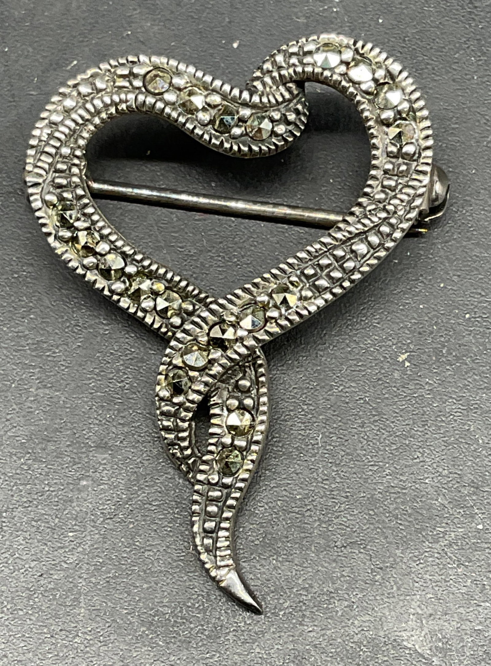 Signed Sterling Silver Marcasite Heart Brooch: Vintage signed Sterling silver and marcasite heart ribbon motif brooch. Marked sterling. Signed partially legible, M. Measures approx. 1.25 x 1 inches. Total weight 3.2 grams. Some scratching. Jewelry