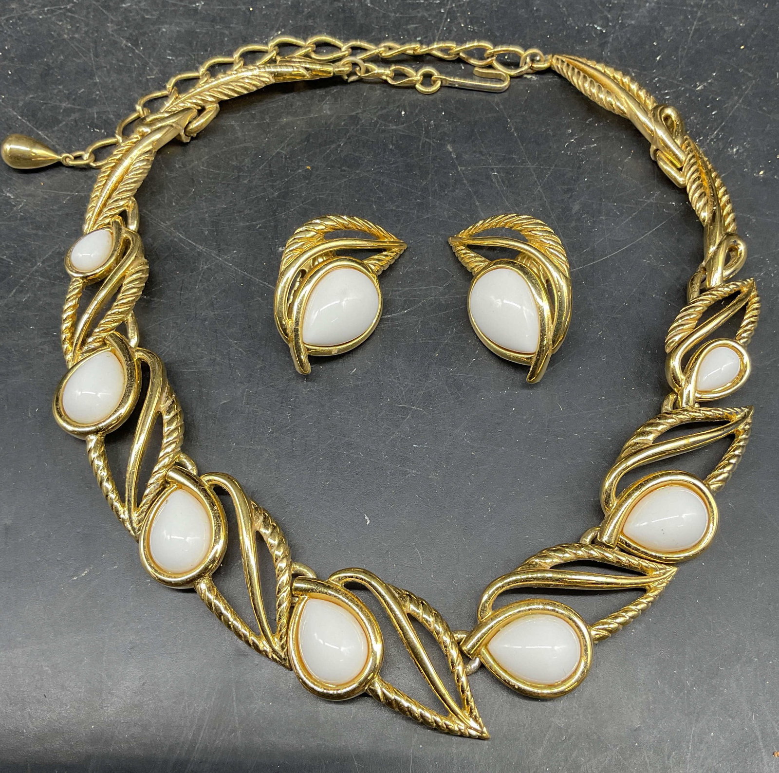 Set 2 Trifari Gold Tone Necklace & Earrings: Set of 2 Vintage matching signed Trifari gold tone and white faux cabochon earrings and panel necklace. Necklace drop length measures approx. 7 inches. Earrings measures approx. 1.5 inches long. Some 