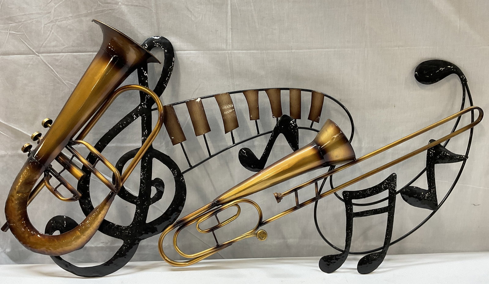 Metal Trumpet Horns Music Wall Decor 39in: Painted metal musical instrument wall decor with trumpet/horn instruments and music notes. Measures approx. 39 x 21 inches. Some scratching. Music wall decor, instrument wall decor, home decor, home