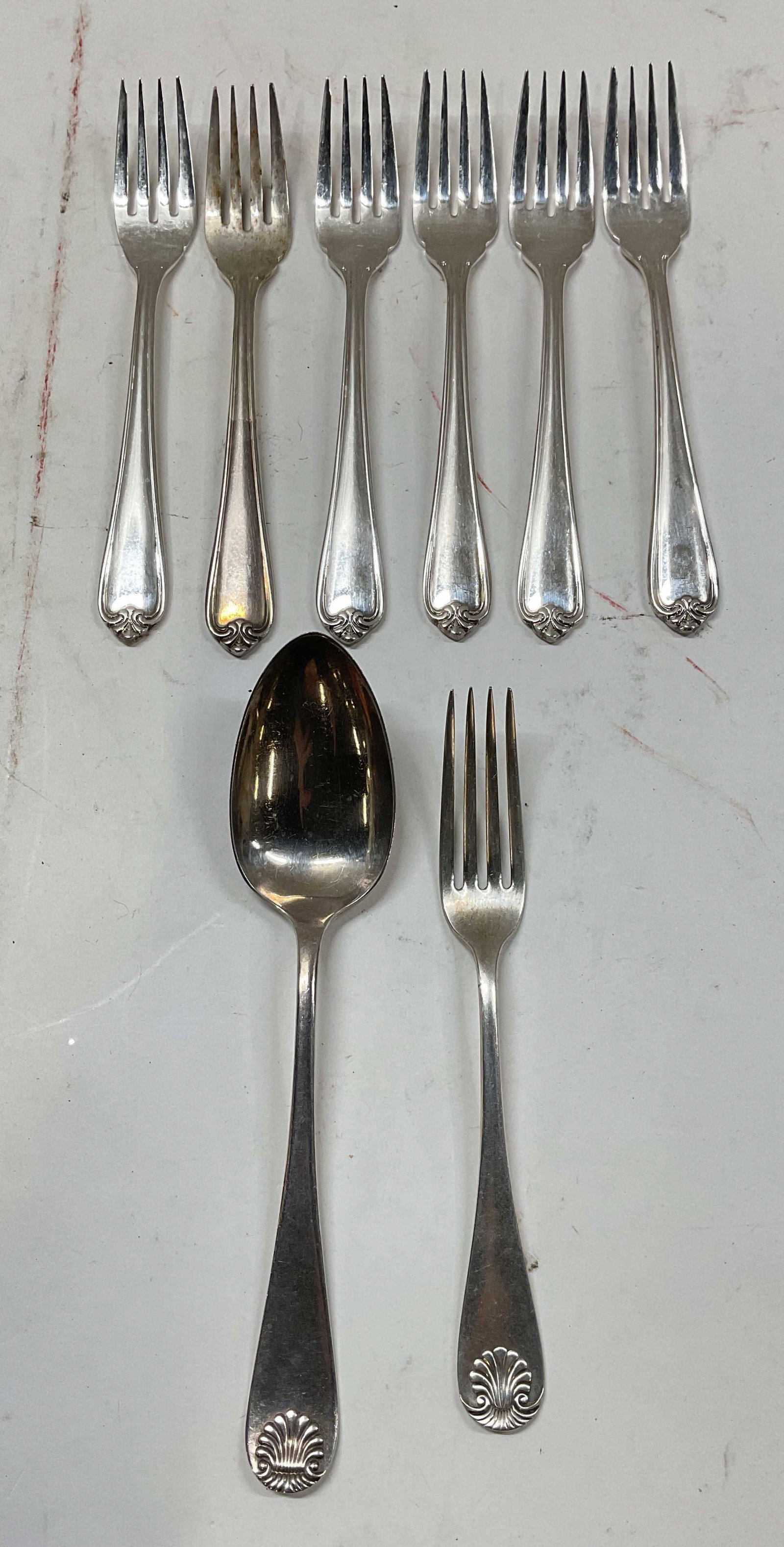 Lot 8 Wallace & Rogers Silver Pl Flatware: Lot of 8 pieces. 6 Wallace silver plated forks. 2 Rogers silver plated spoon and fork. Scroll handles, largest piece measures approx. 8 inches long. All pieces he patina and scratching. Wallace
