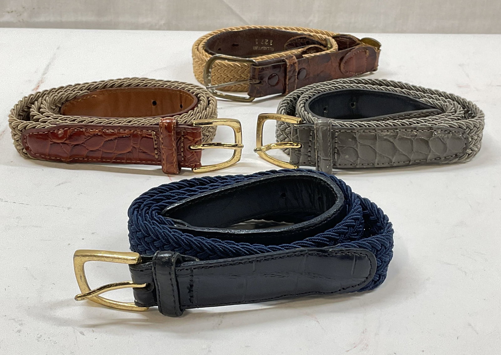 Lot 4 Braided Fabric & Leather Belts: Lot of 4 braided fabric belts with leather accents in tan, grey, and blue. Sizes 32 and 34. Some wear to all including blemishes, rubbing and scratching to leather. Belt, braided belt, fabric belt, le