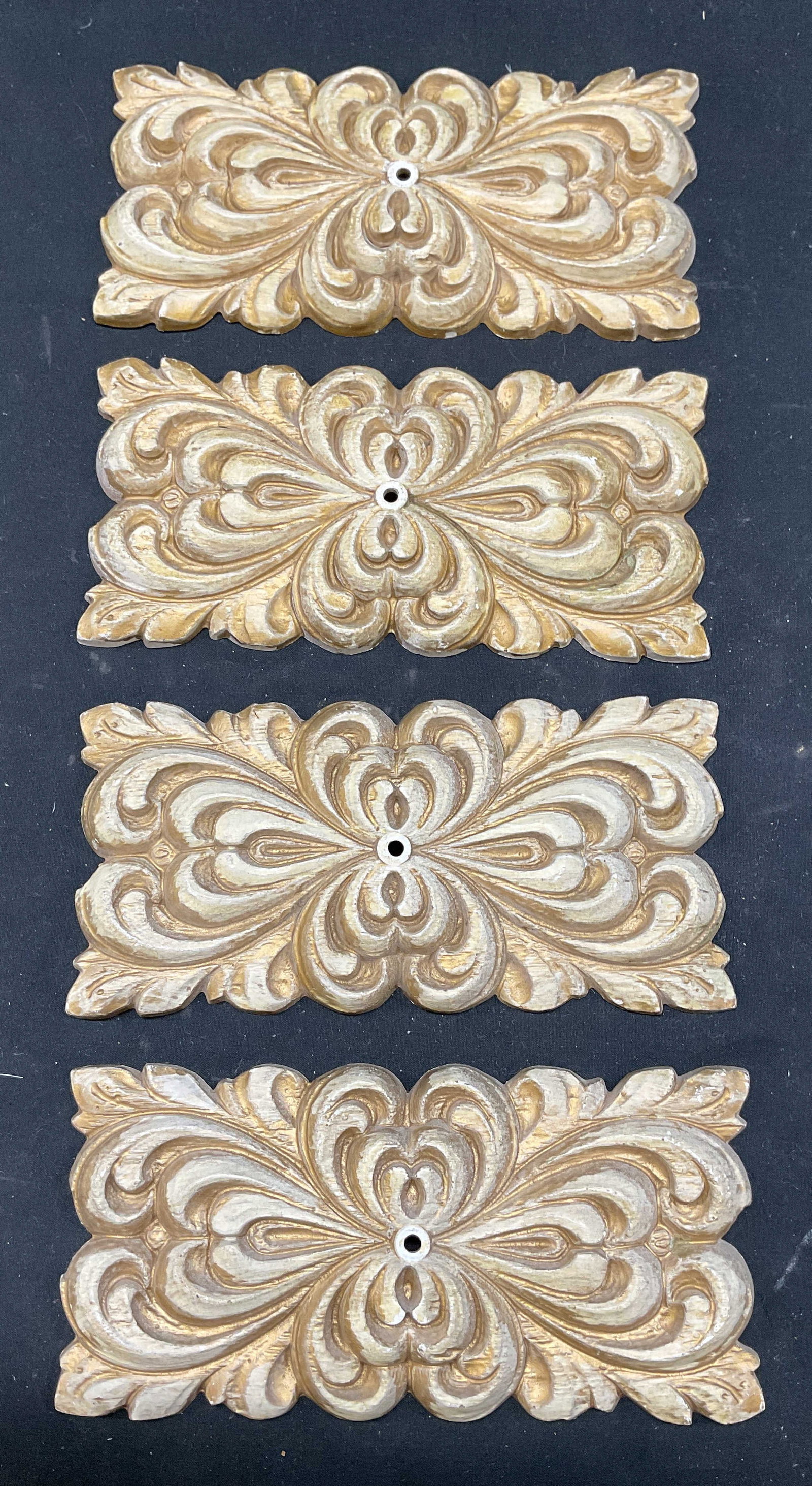 Set 4 Ronthor NYC Gilt Scroll Wall Plaques: Set of 4 Vintage Ronthor NYC ornate scroll motif wall plaques. Gilt decoration on cream white. Plastic. Measures approx. 7.5 x 3.5 inches. Some scratching and loss to paint. Some pieces chipped on rev