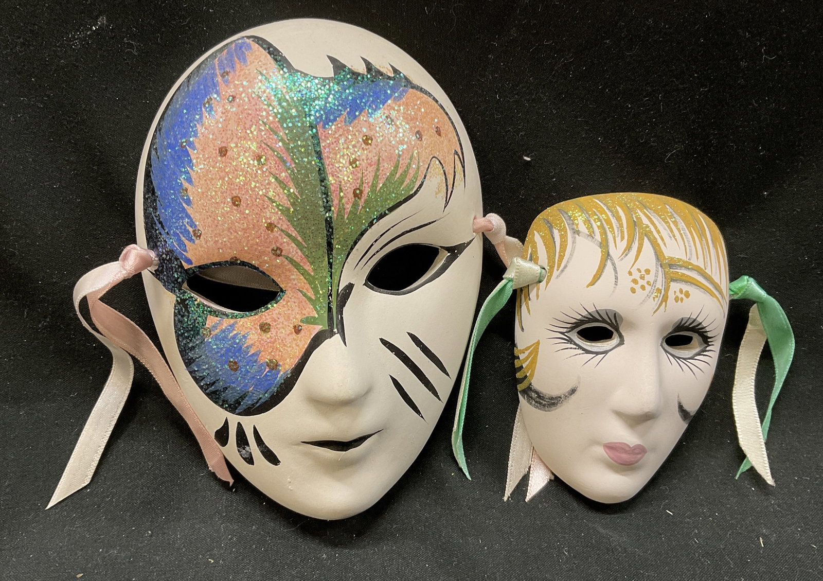 Lt 2 Ceramic Decorative Mardi Gras Masks: Lt 2 Ceramic Decorative Mardi Gras Masks. Hand-Painted. Larger has Colorful Pink, Blue, and Green Glitter Accents. Smaller has Gold Toned Glitter Hair and Prominent Eyelashes. Condition Consistent wit