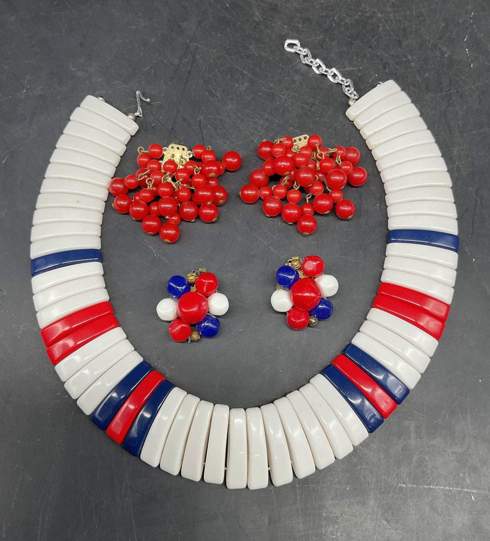 Lot 3 Red White & Blue Necklace & Earrings: Lot of 3 jewelry pieces. Red, white and blue beaded panel necklace, earrings, and red beaded earrings. Necklace drop length measures approx. 6 inches. Larger earrings measures approx. 1.5 inches long.