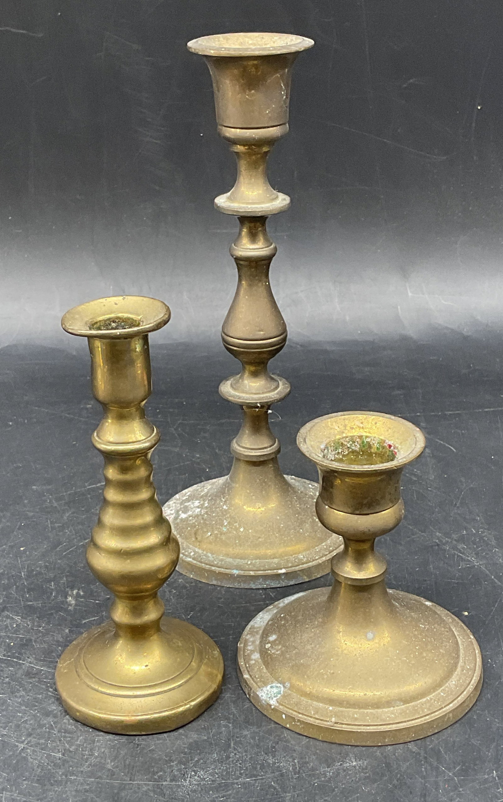 Lot 3 Vintage Brass Candle Holders, India: Lot of 3 vintage brass candle holders. 2 marked made in India. Largest measures approx. 3 x 7 inches. All pieces have wear including patina and scratching. Brass candle holder, vintage candle holder, 