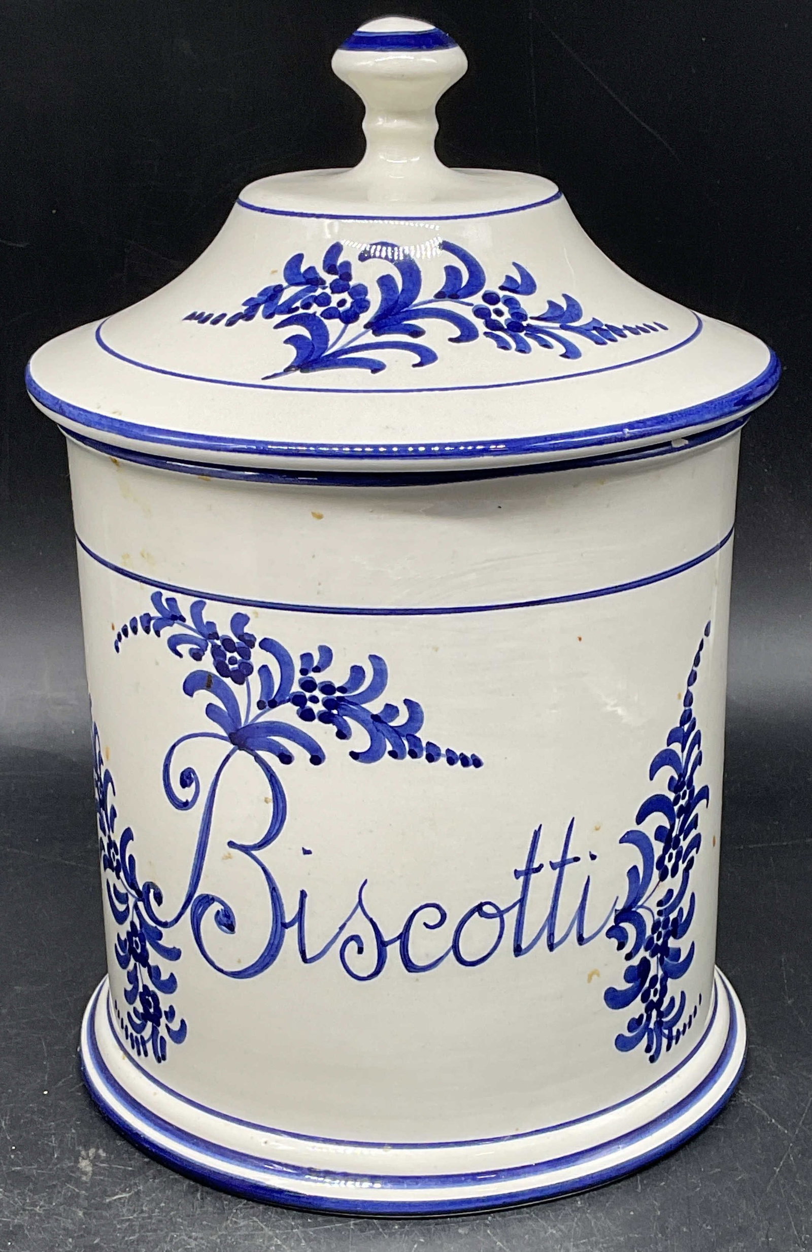 Lillian Vernon Ceramic Biscotti Jar, Italy: Lillian Vernon blue and white ceramic lidded Biscotti jar. Hand painted with floral motif. Made in Italy. Measures approx. 6 x 9 inches. Some scratching and small chips. Lillian Vernon jar, ceramic ja