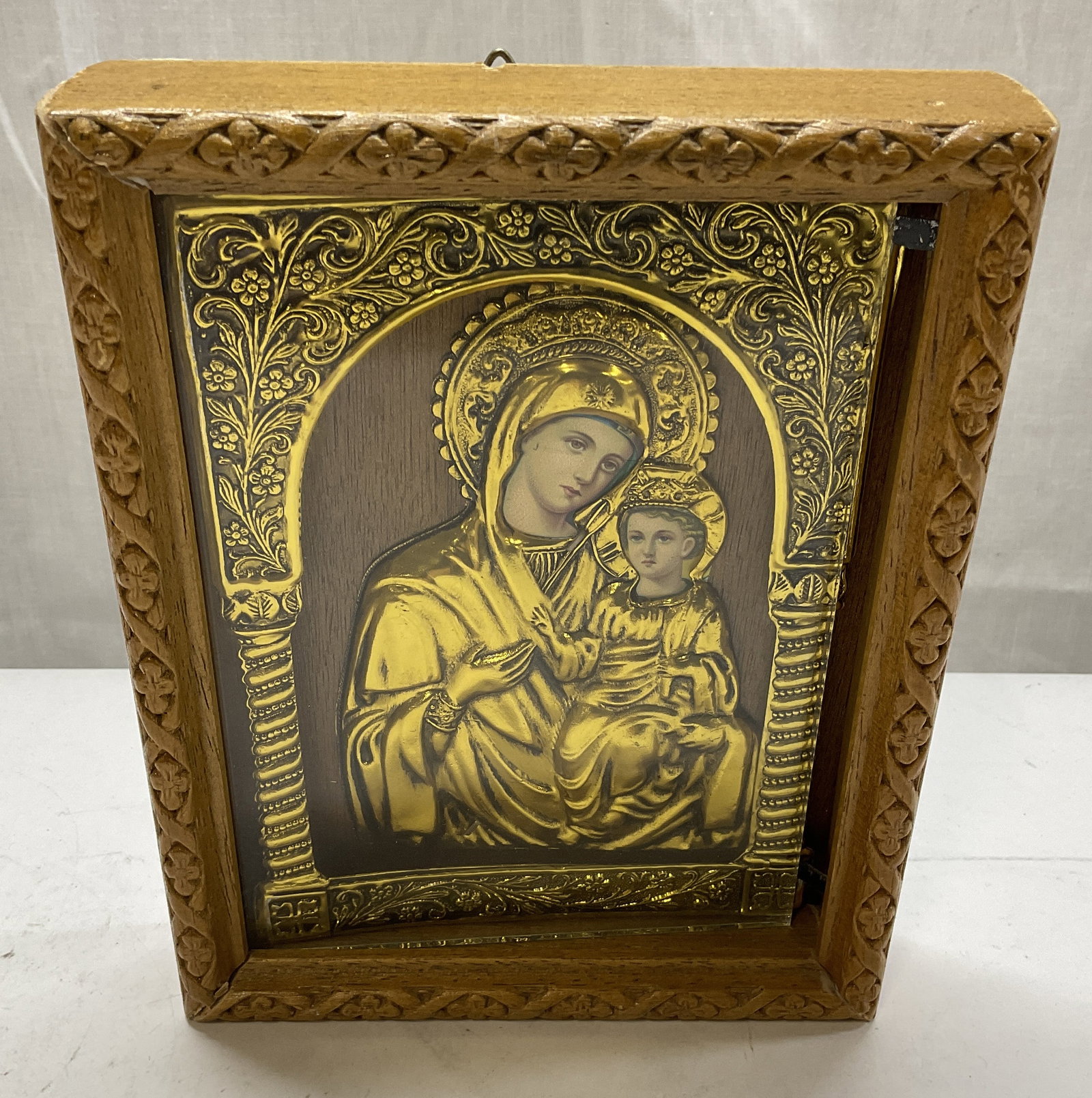 Holoviaks Church Supp Gilt Metal Virgin Mary+: Holoviaks Church Supply Gilt Metal Covered Print of Virgin Mary and Christ Child. Intricately Carved Floral Wooden Frame. Condition Consistent with Exposure. Frame Needs Adjustment. Measures app 6.5in