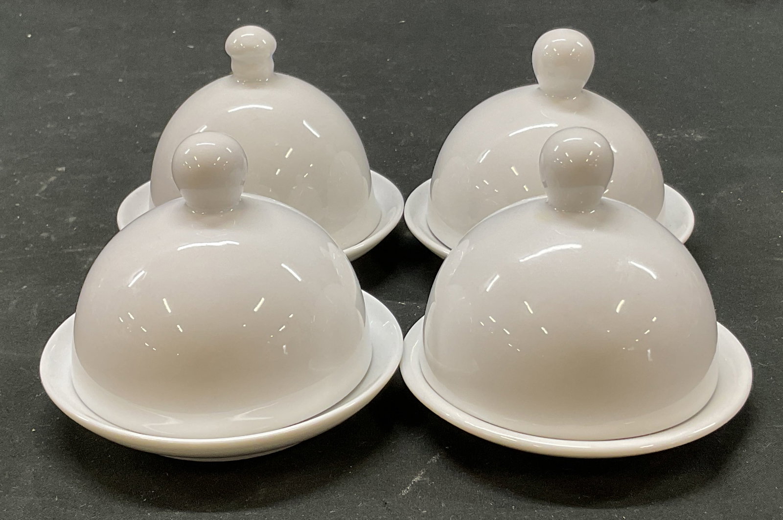 Set 4 Home White Porcelain Lidded Butter Dishes: Set of 4 Home white porcelain lidded butter dishes. Marked on underside. Round dish with compartment for butter. Domed lid with decorative finial. Measures ht approx 3.5 inches diam approx 4 inches. S